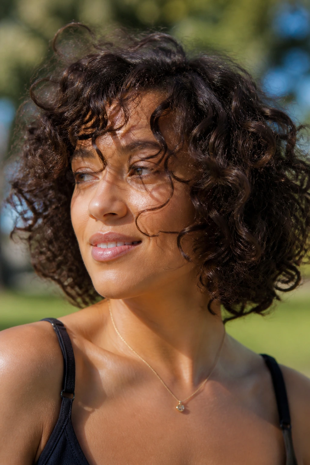 Close-up of a real woman with a move-friendly 3A cut, outdoors.