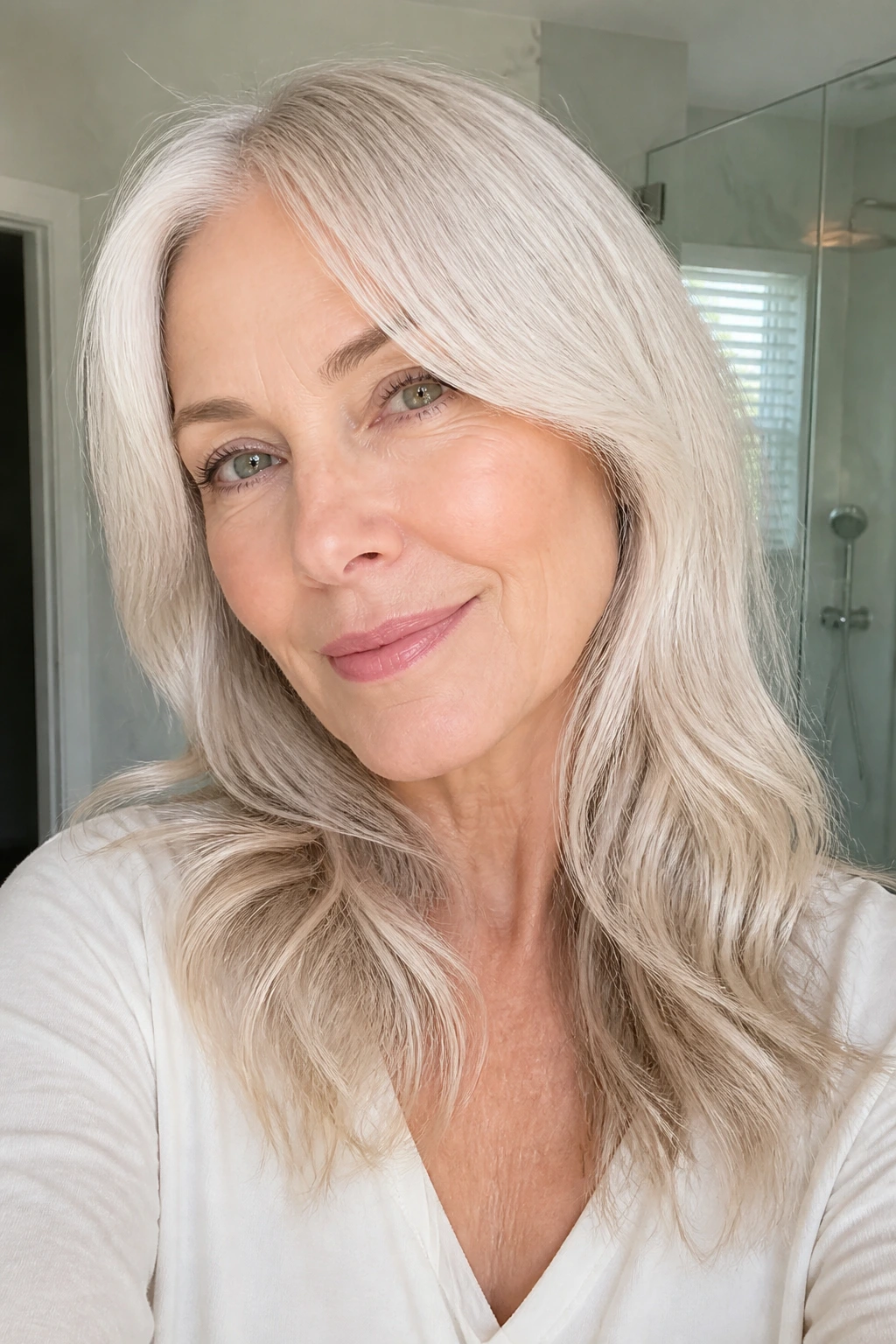 Portrait of a woman with almond milk blonde hair in a bright bathroom