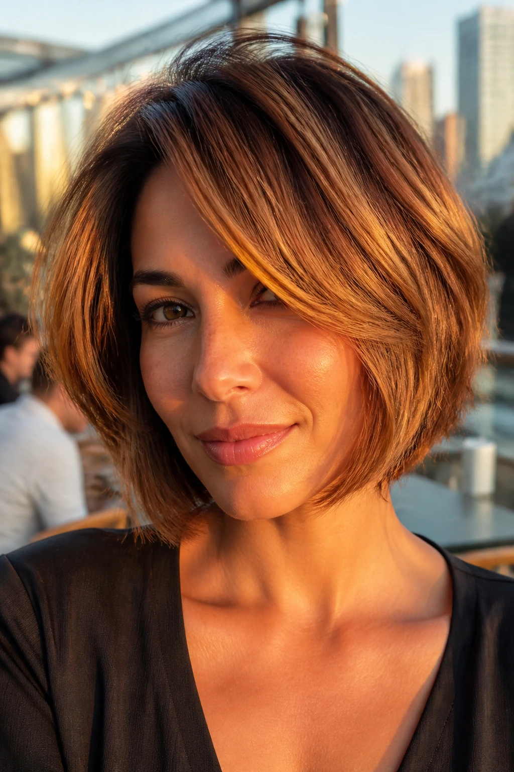 Amber layered bob on a real person with amber highlights lifting the short layers.