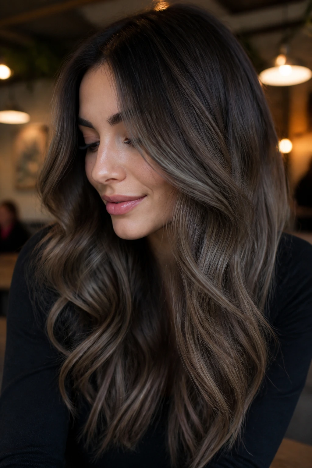 Close-up of brunette with ashy walnut balayage and ash ribbons.