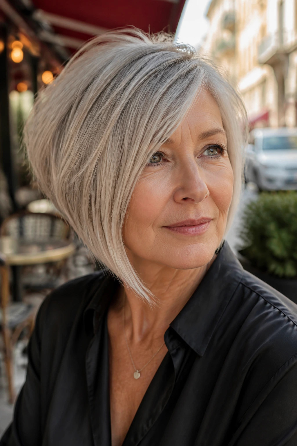 Close-up portrait of a woman with an asymmetrical layered bob showing a longer diagonal side and soft layers.
