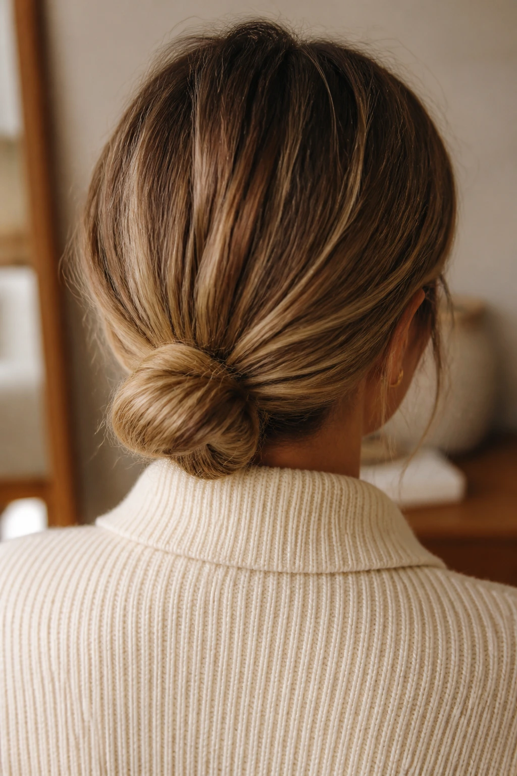 Back view of a real person showing a low bun at the nape of the neck.
