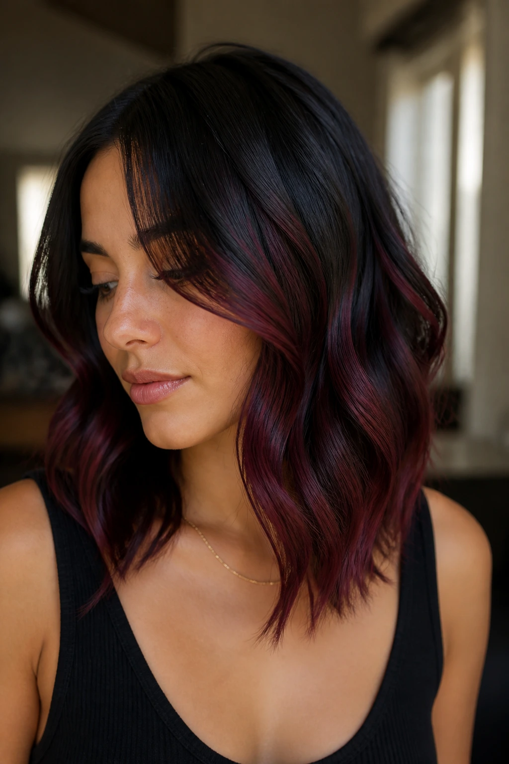Close-up of a woman with black hair and red-violet balayage
