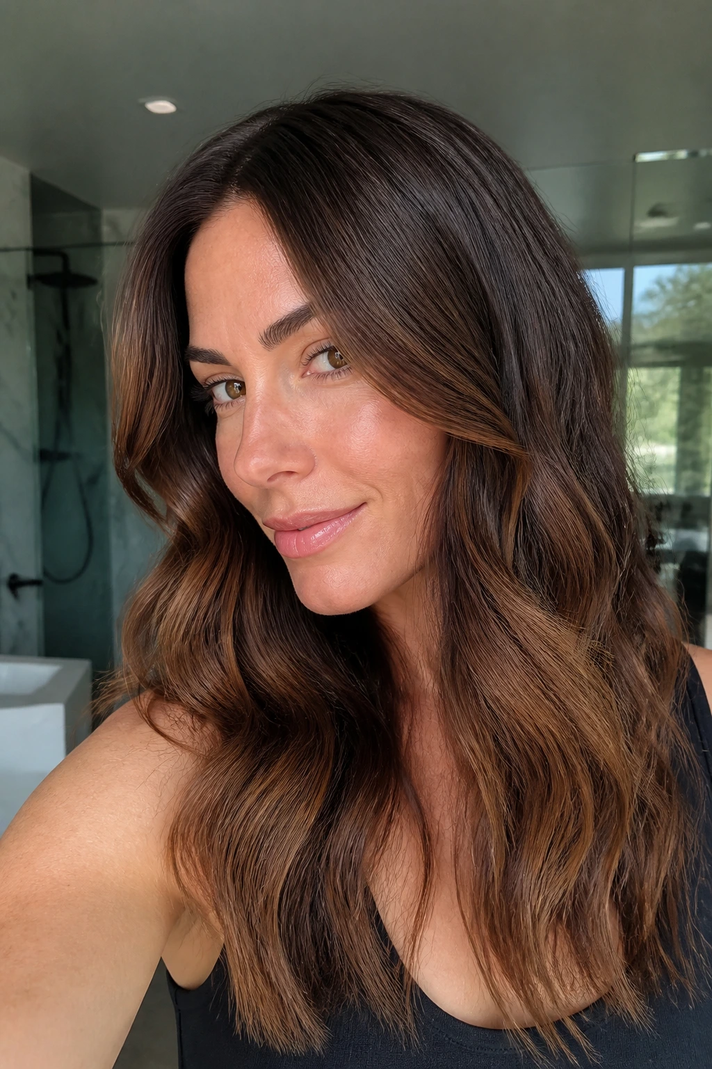 Close-up portrait of a real brunette with chestnut balayage and shadow roots