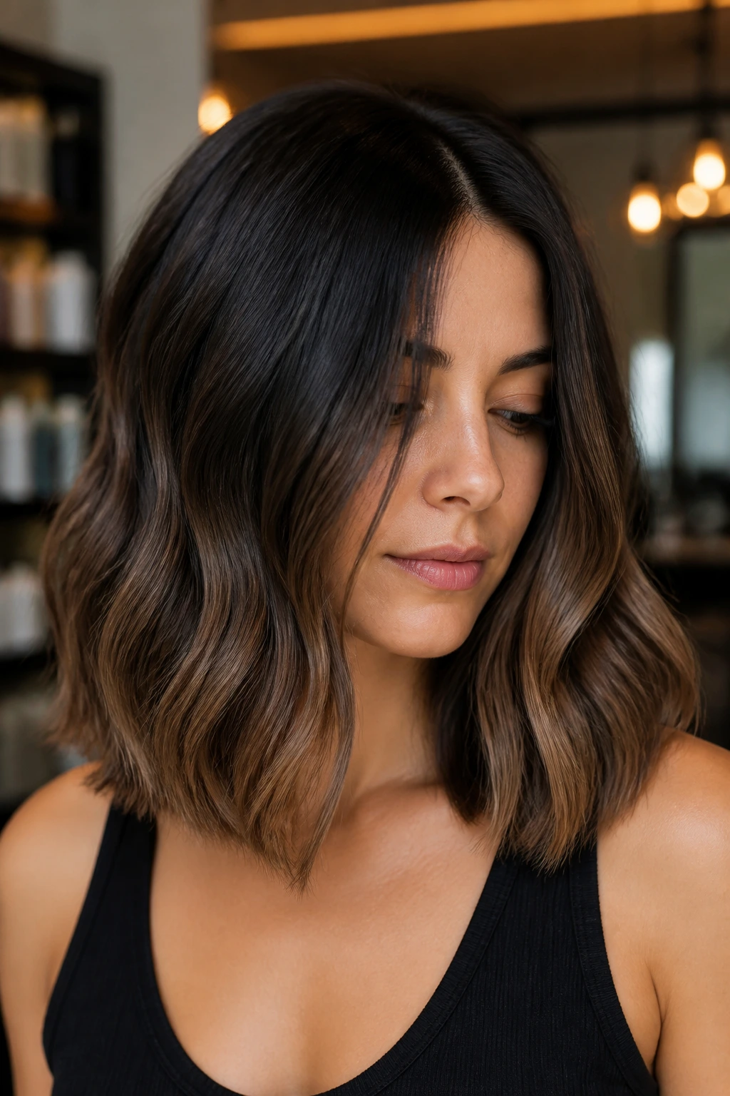 Close-up portrait of a real woman with espresso-to-mocha balayage on shoulder-length hair