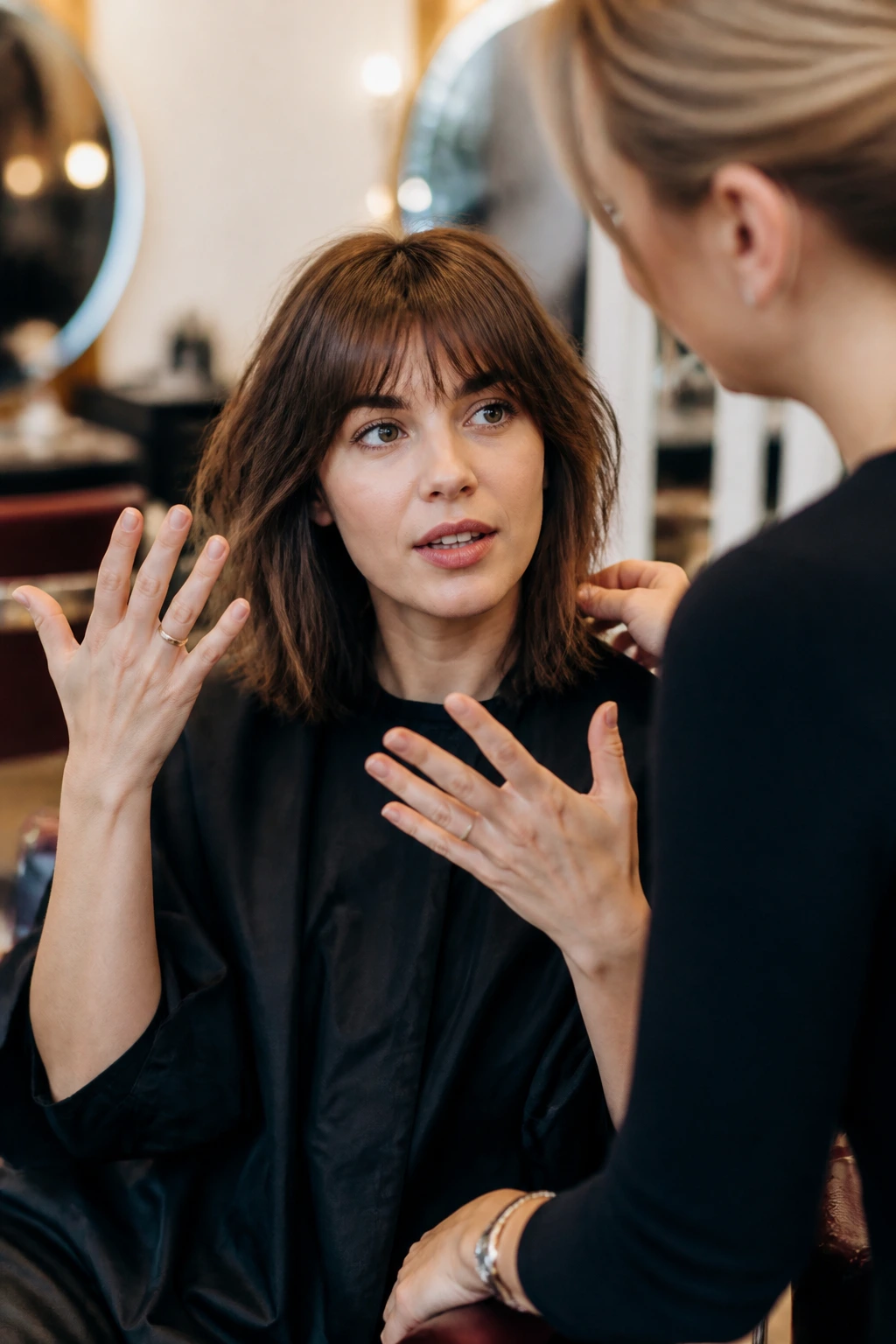 Close-up of client consulting stylist about bangs in a warm salon