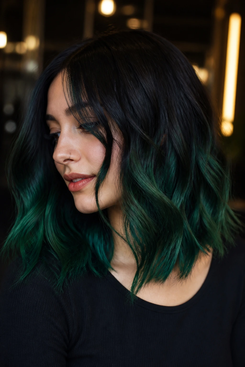 Portrait of hair transitioning from black roots to emerald ends on medium-length hair