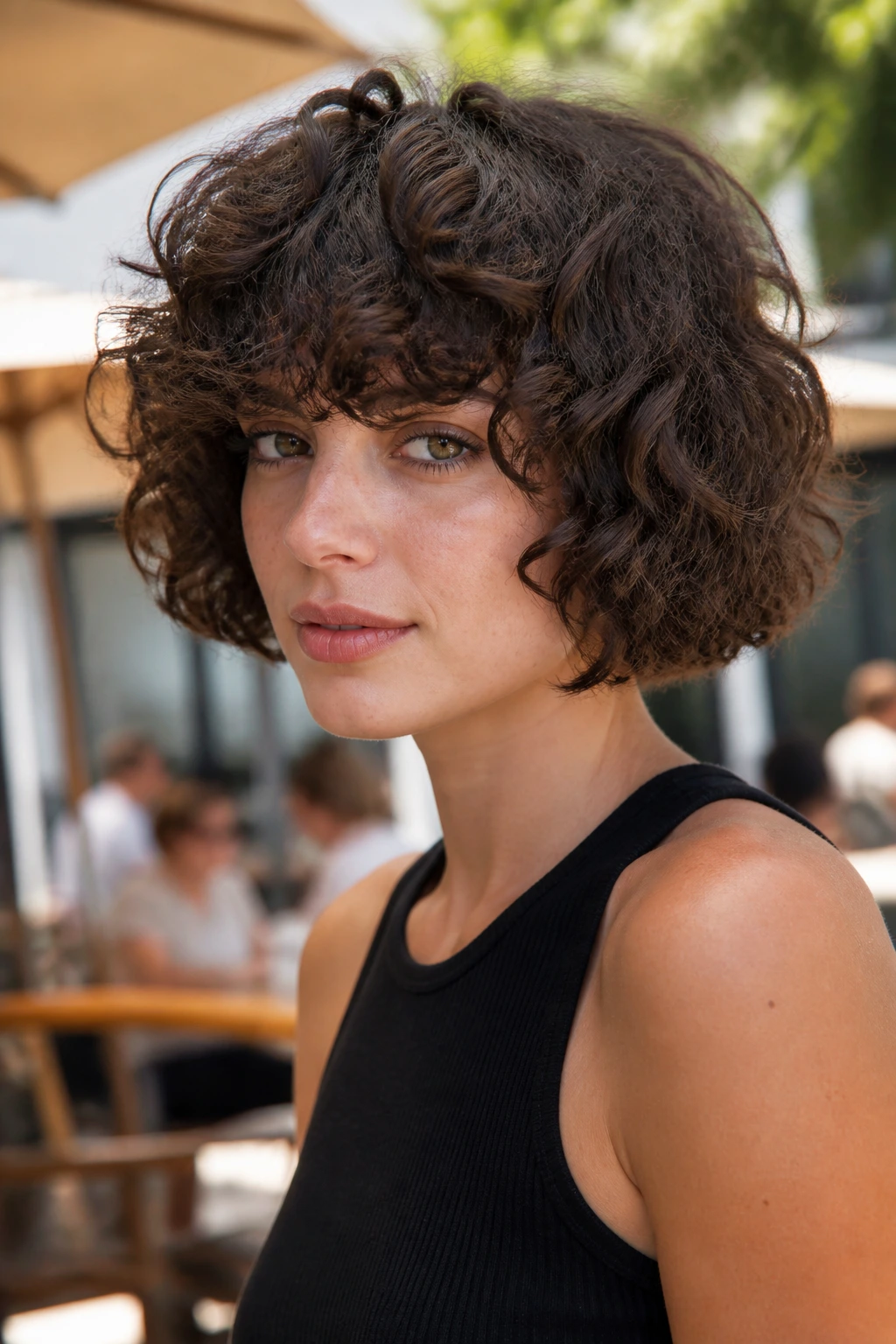 Portrait of a real woman with blunt bob and heavy curly bangs in daylight