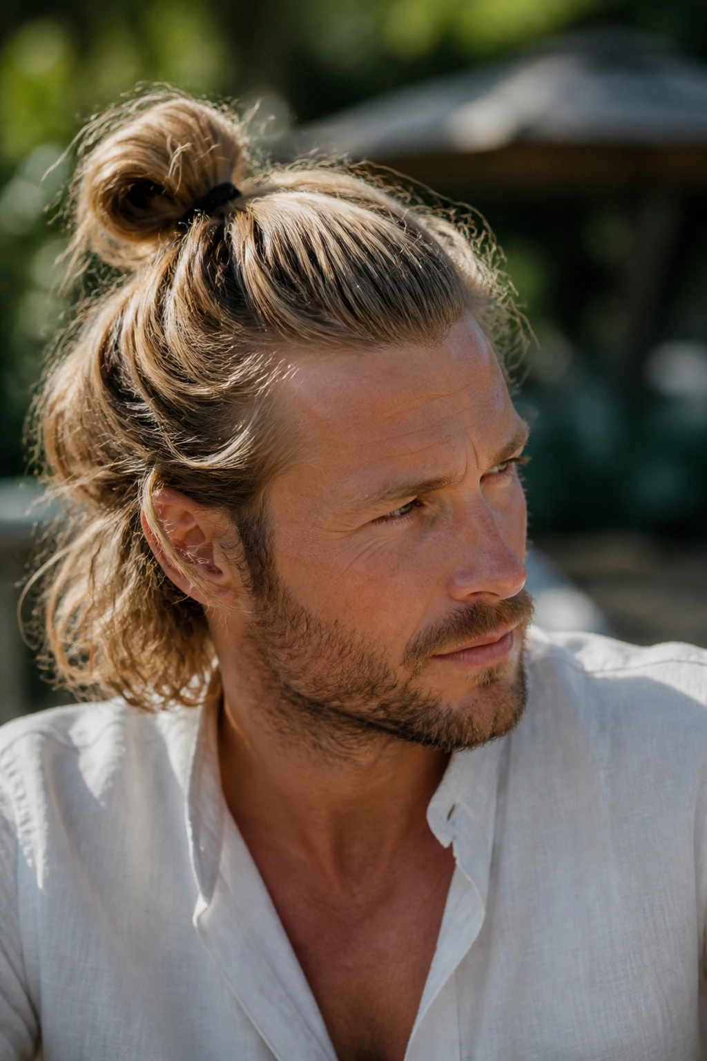 Close-up portrait of a man with a boho loose knot in an outdoor setting