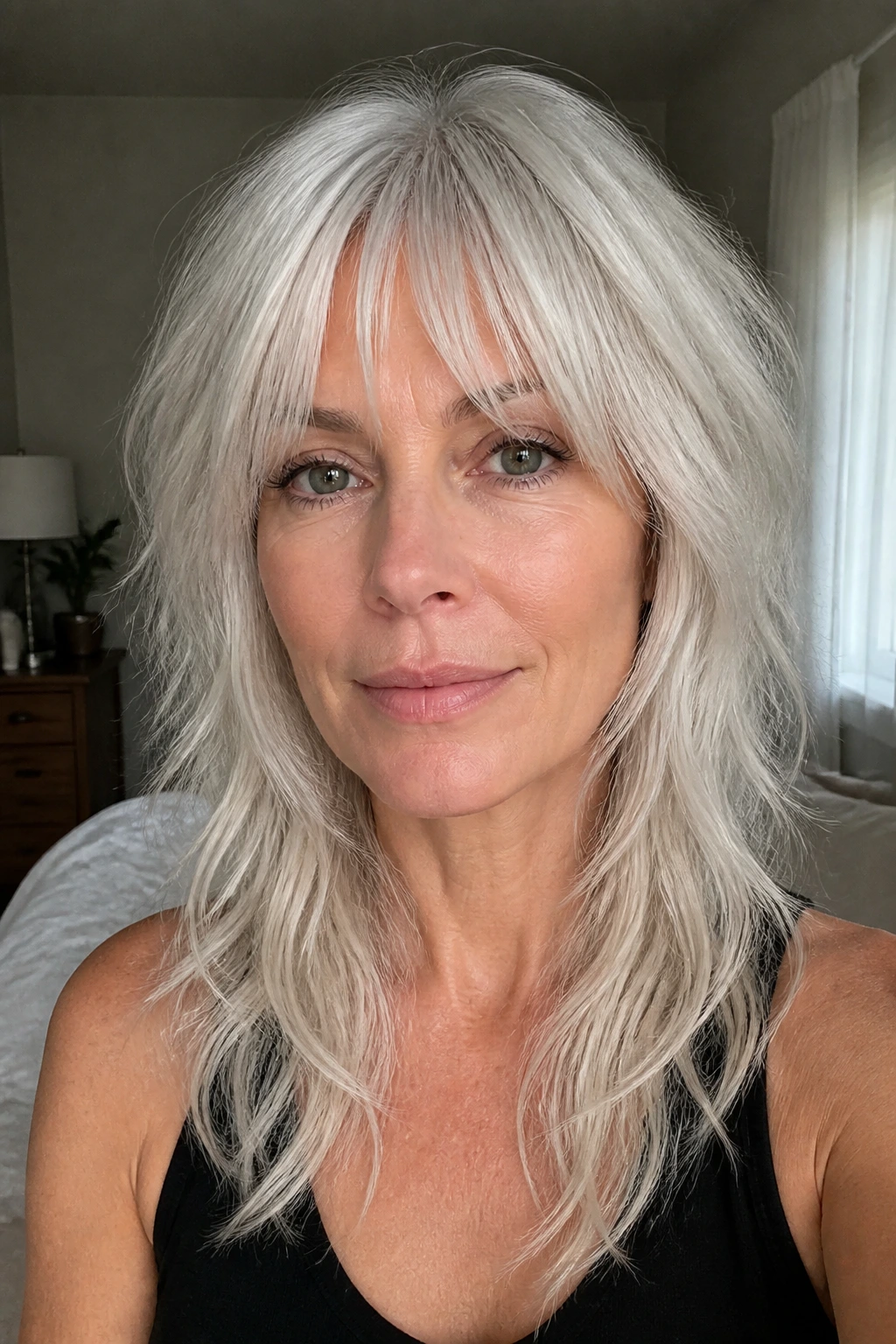 Close-up of a woman with bottleneck bangs platinum wolf cut