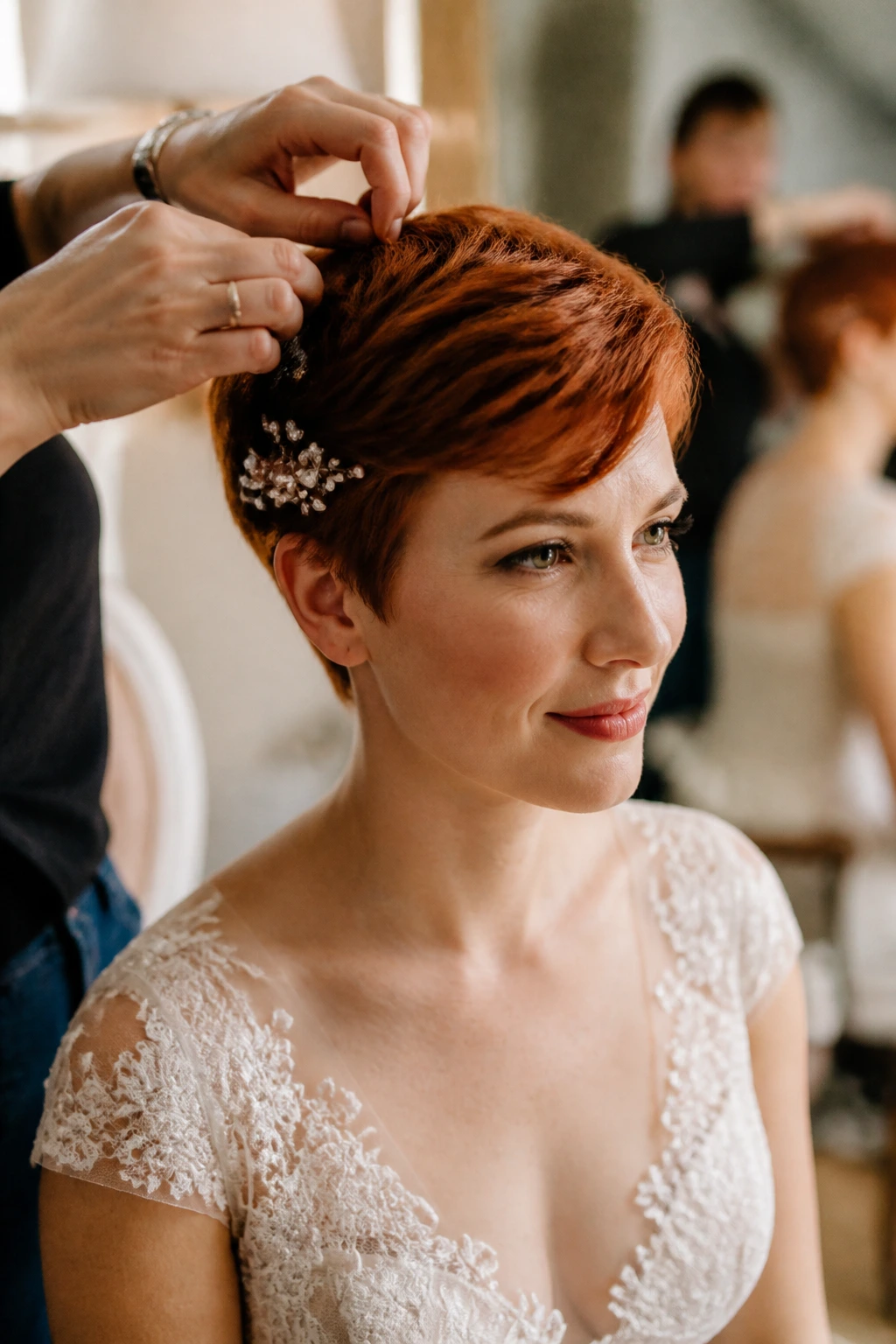Close-up of a real bride with short copper-red hair during wedding-day prep and hair touch-ups