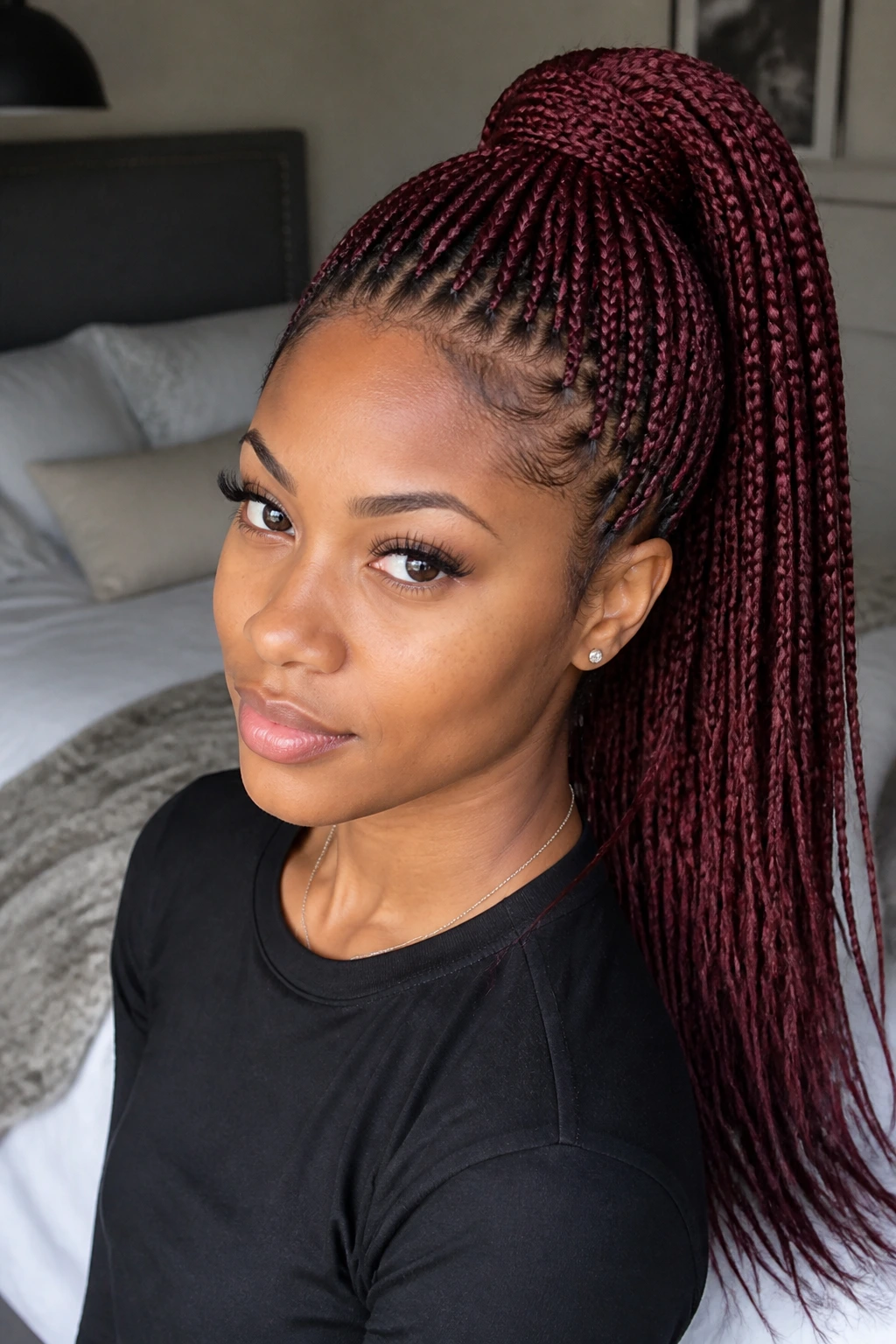 Close-up of a real woman's burgundy knotless braids in a high ponytail