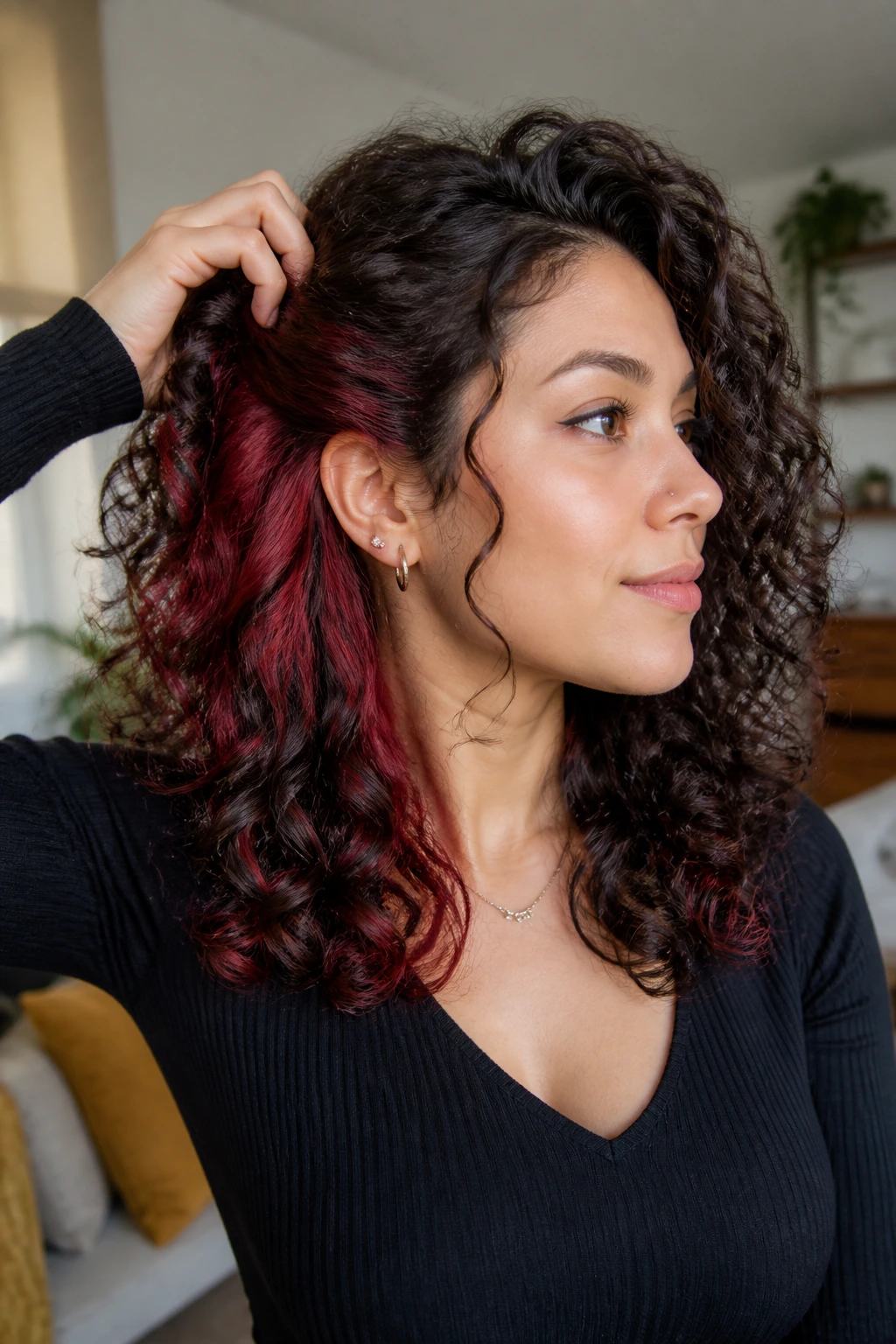 Close-up of burgundy peekaboo panels under curl layer on a real woman