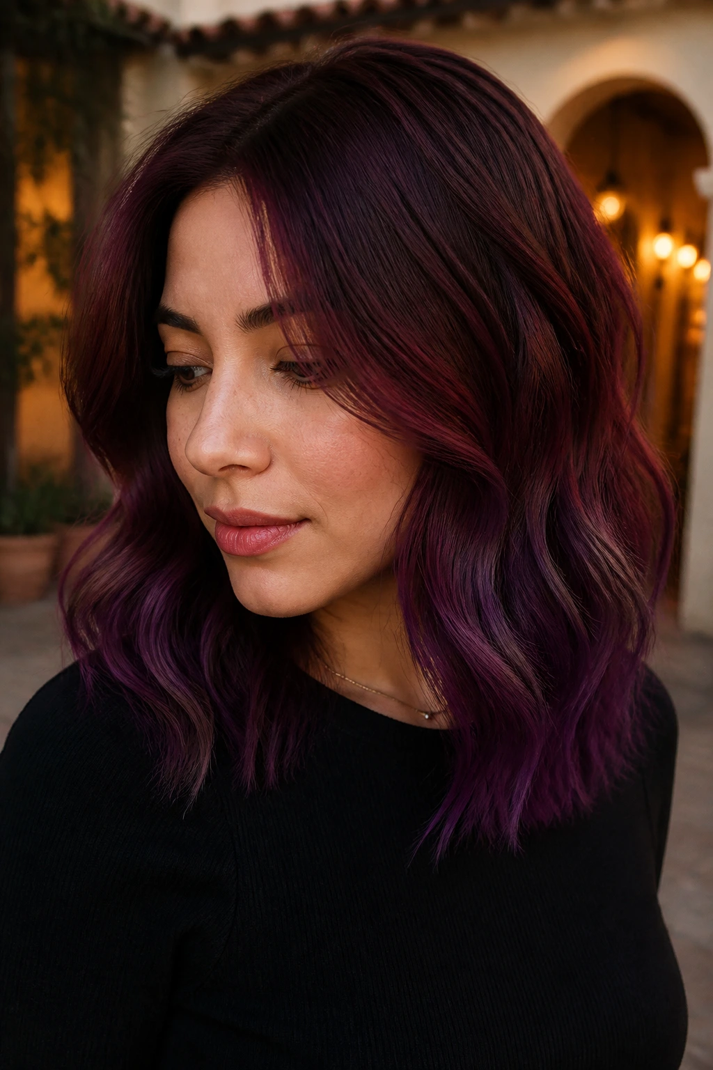 Real woman with burgundy to plum ombre on shoulder-length hair.