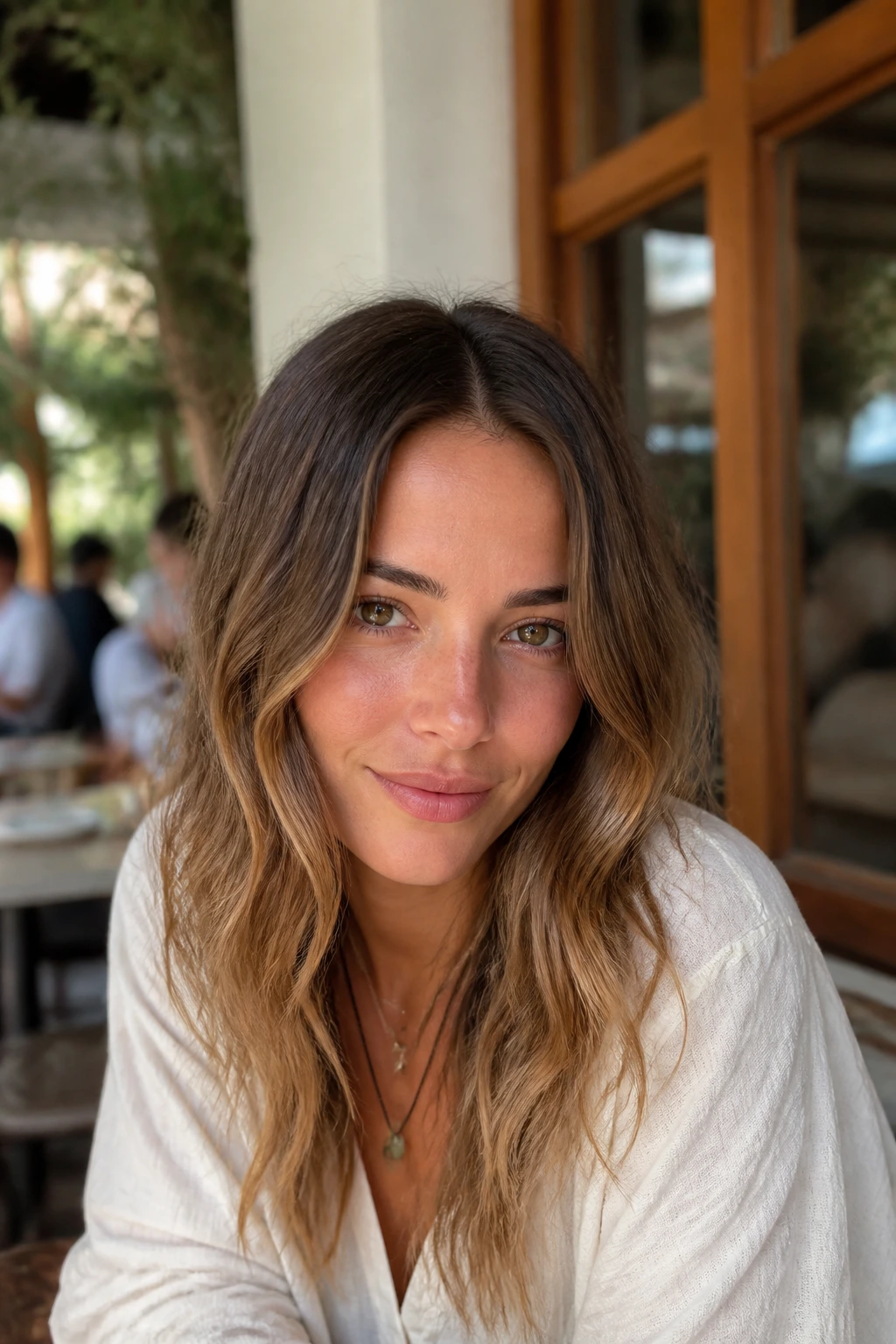 Close-up of a real woman with center-parted loose waves in sunlit setting