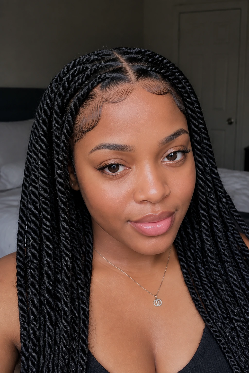 Real woman with center-part twists and baby hairs framing the face
