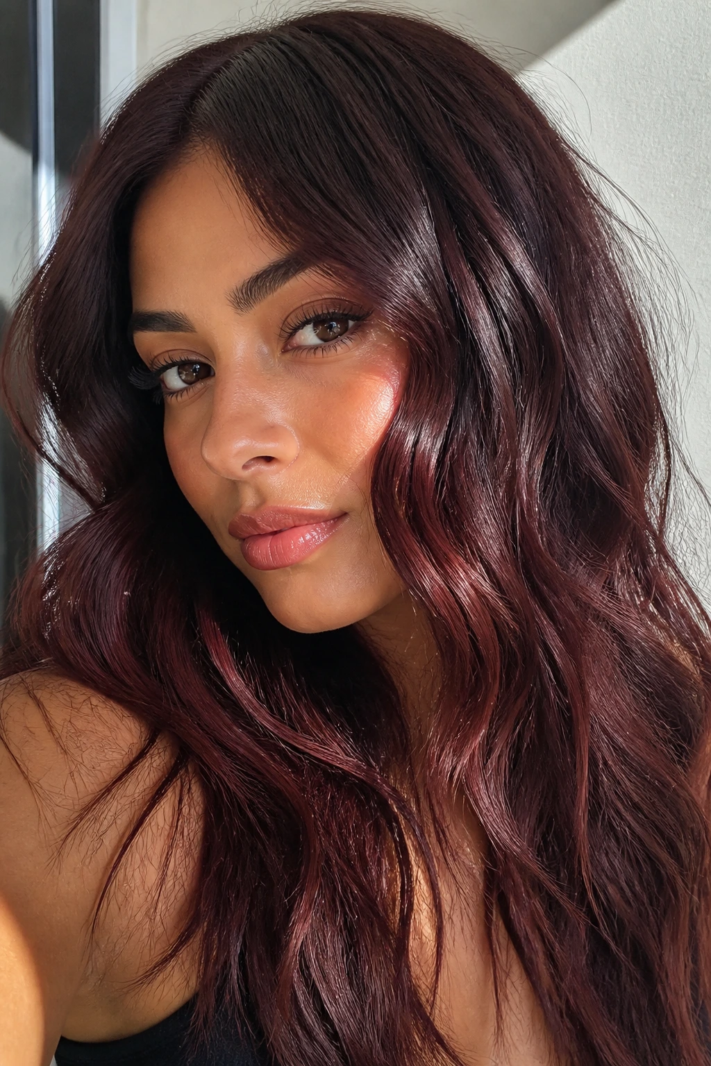 Chocolate brown hair with cherry-violet tint catching light