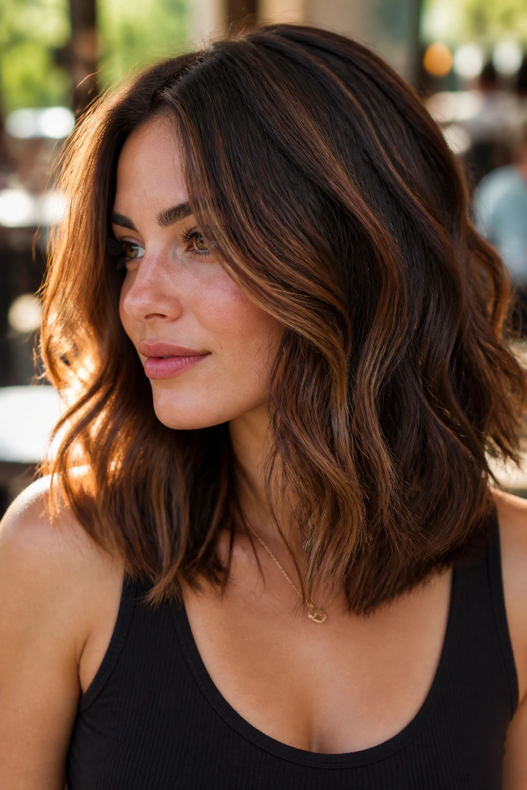 Portrait of a woman with chocolate brown hair and cinnamon balayage ribbons