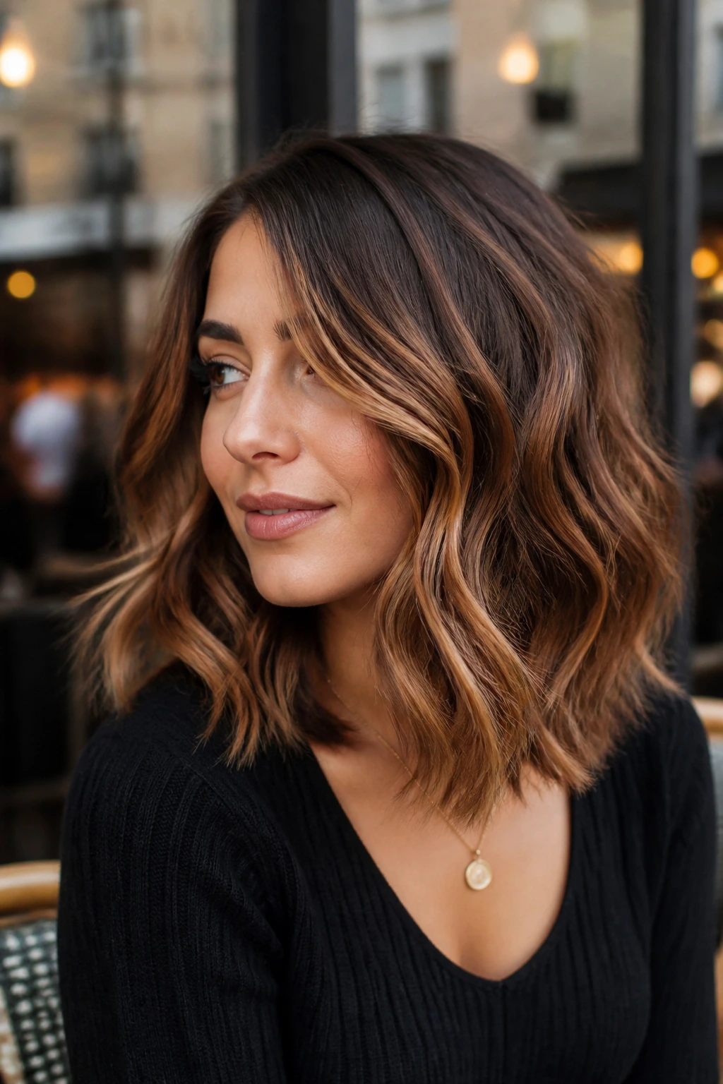 Real woman with cinnamon and toffee balayage on medium brunette, warm face-framing ribbons