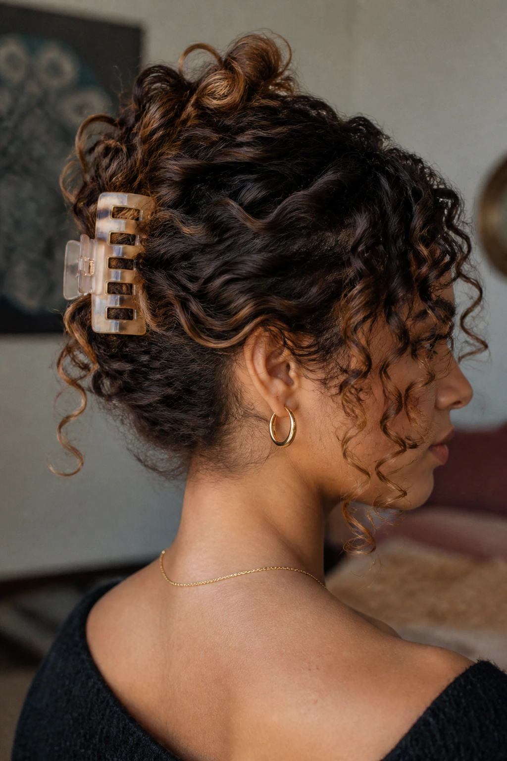 Close-up of a real person with a claw-clip French twist and curls spilling at back