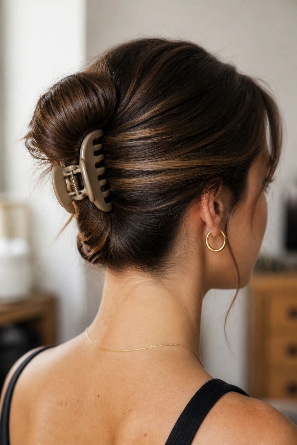 Portrait of a real person showing a claw-clip pocket bun secured at the nape