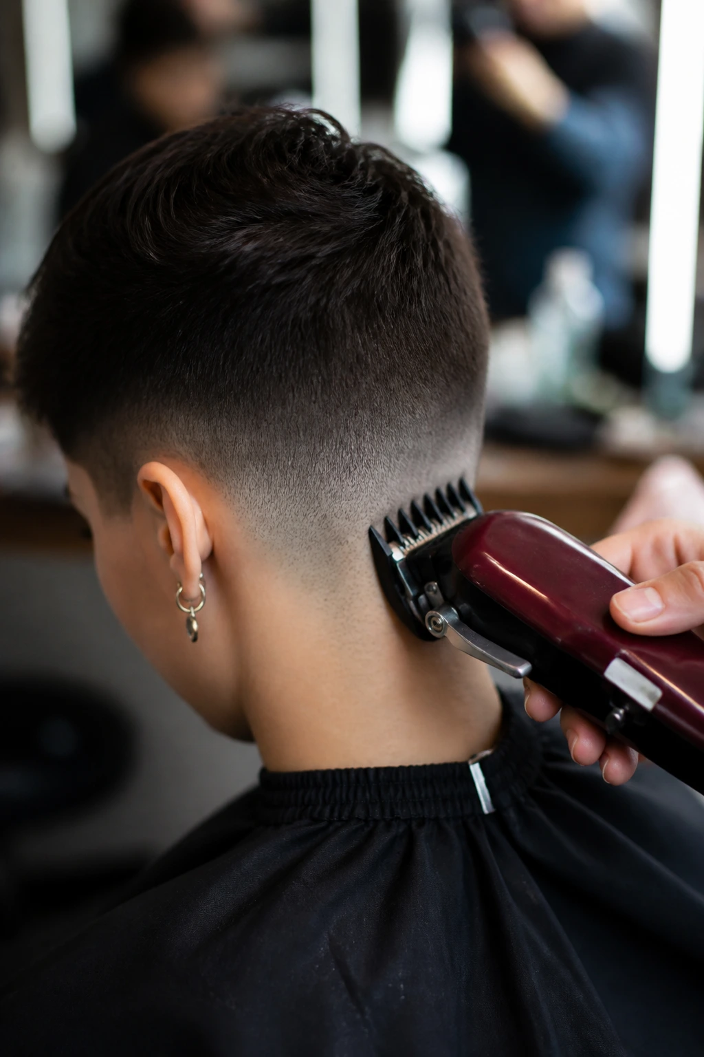 Close-up of clippers trimming a real client's nape in a salon