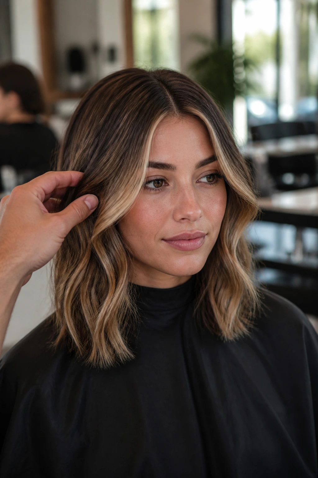 Real client in a salon chair with hair parted to show placement for balayage