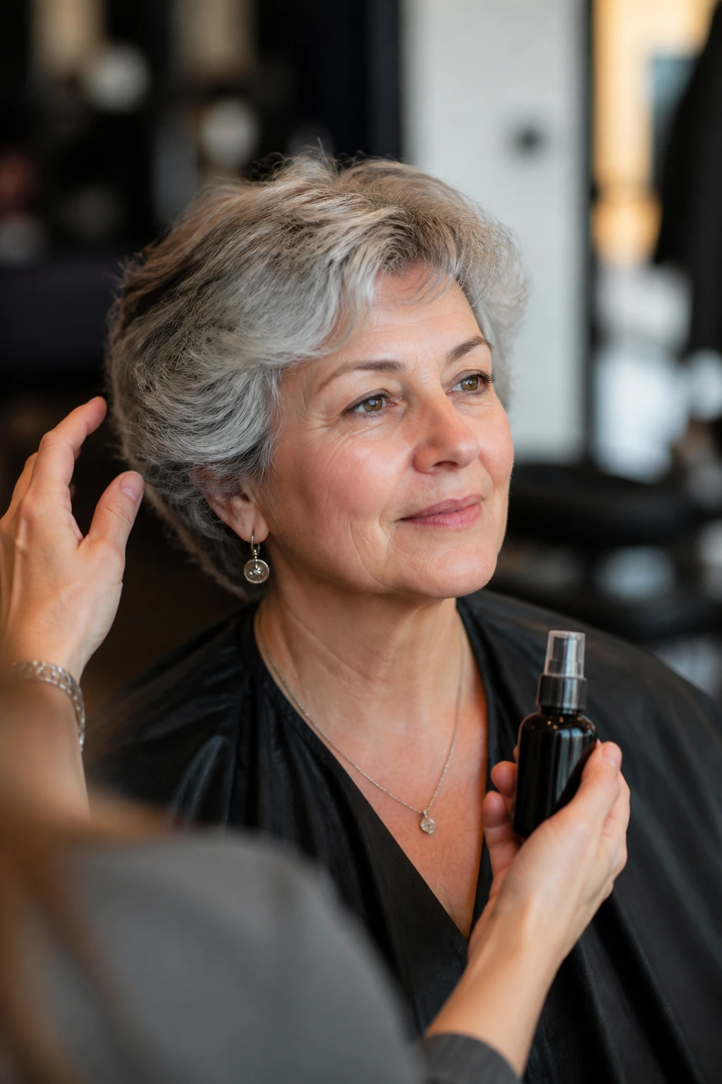 Real woman in salon chair discussing haircut and products with a calm expression.