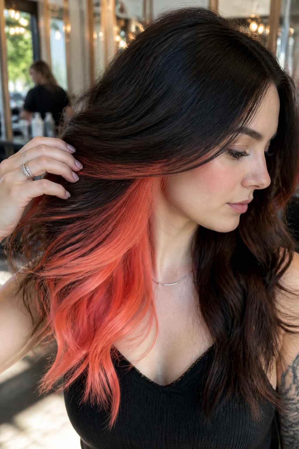 Close-up of brunette with coral underlights visible beneath the surface
