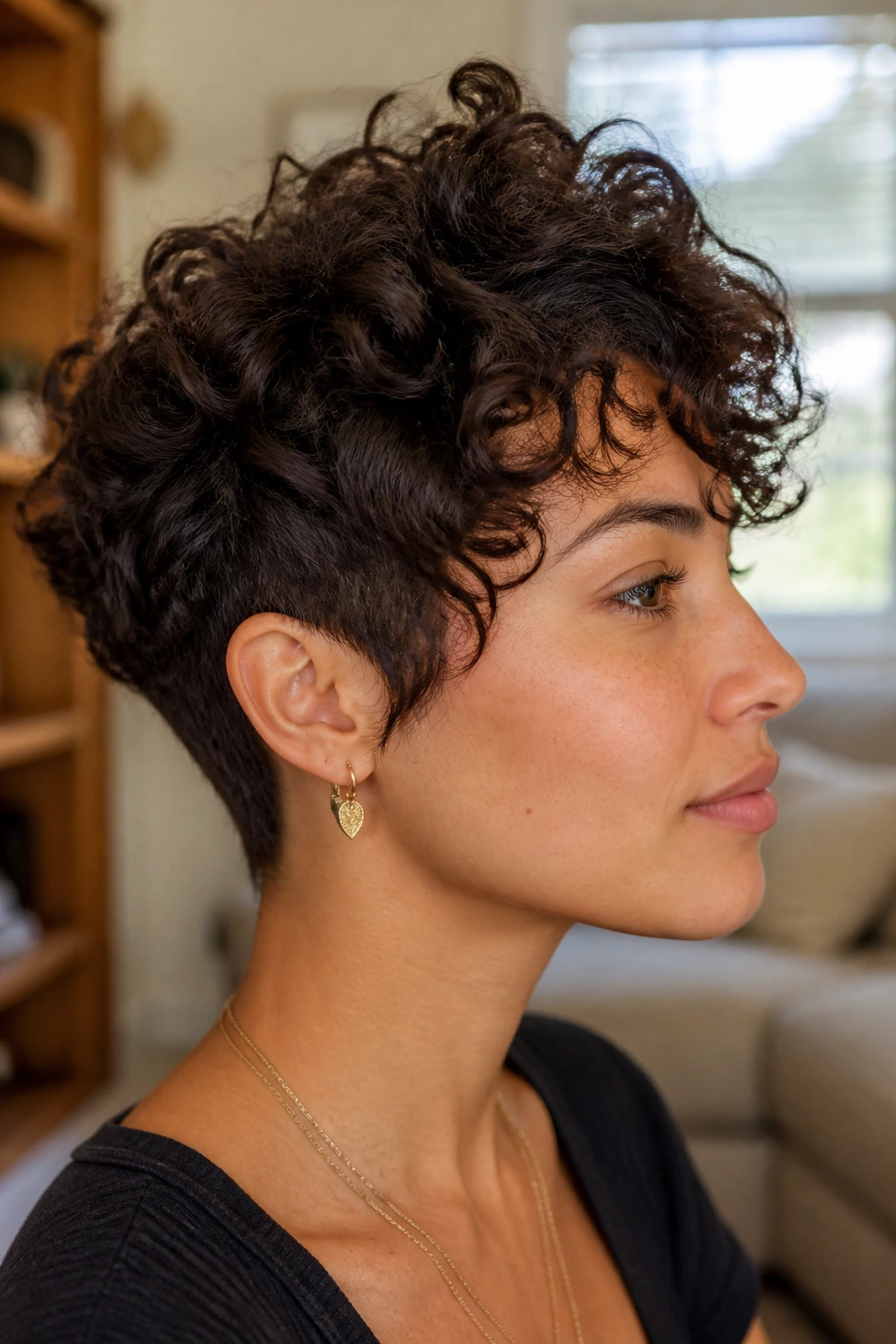 Profile portrait of woman with crown-lift pixie wolf haircut in a warm living room