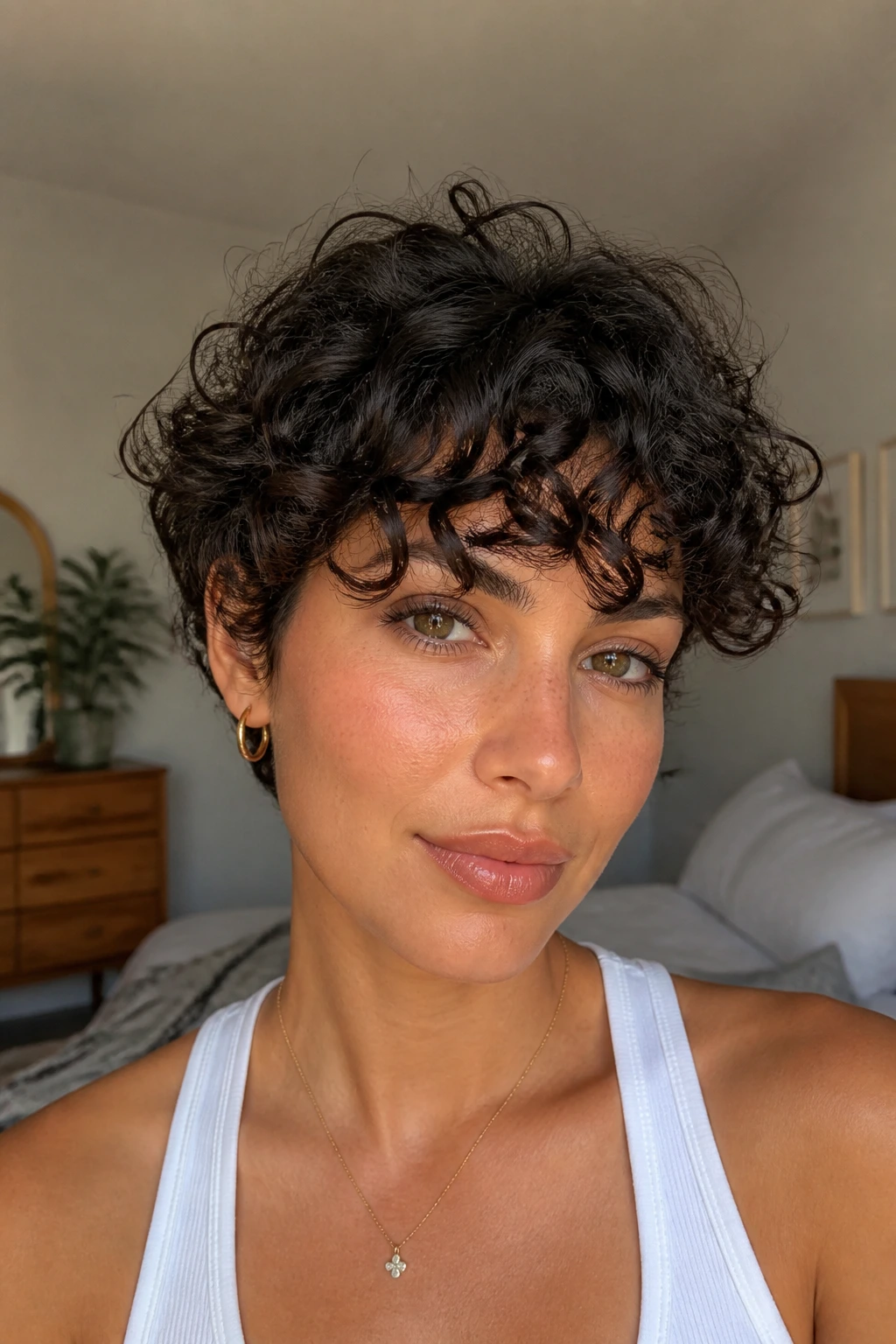 Real woman with short curly bangs framing her forehead.