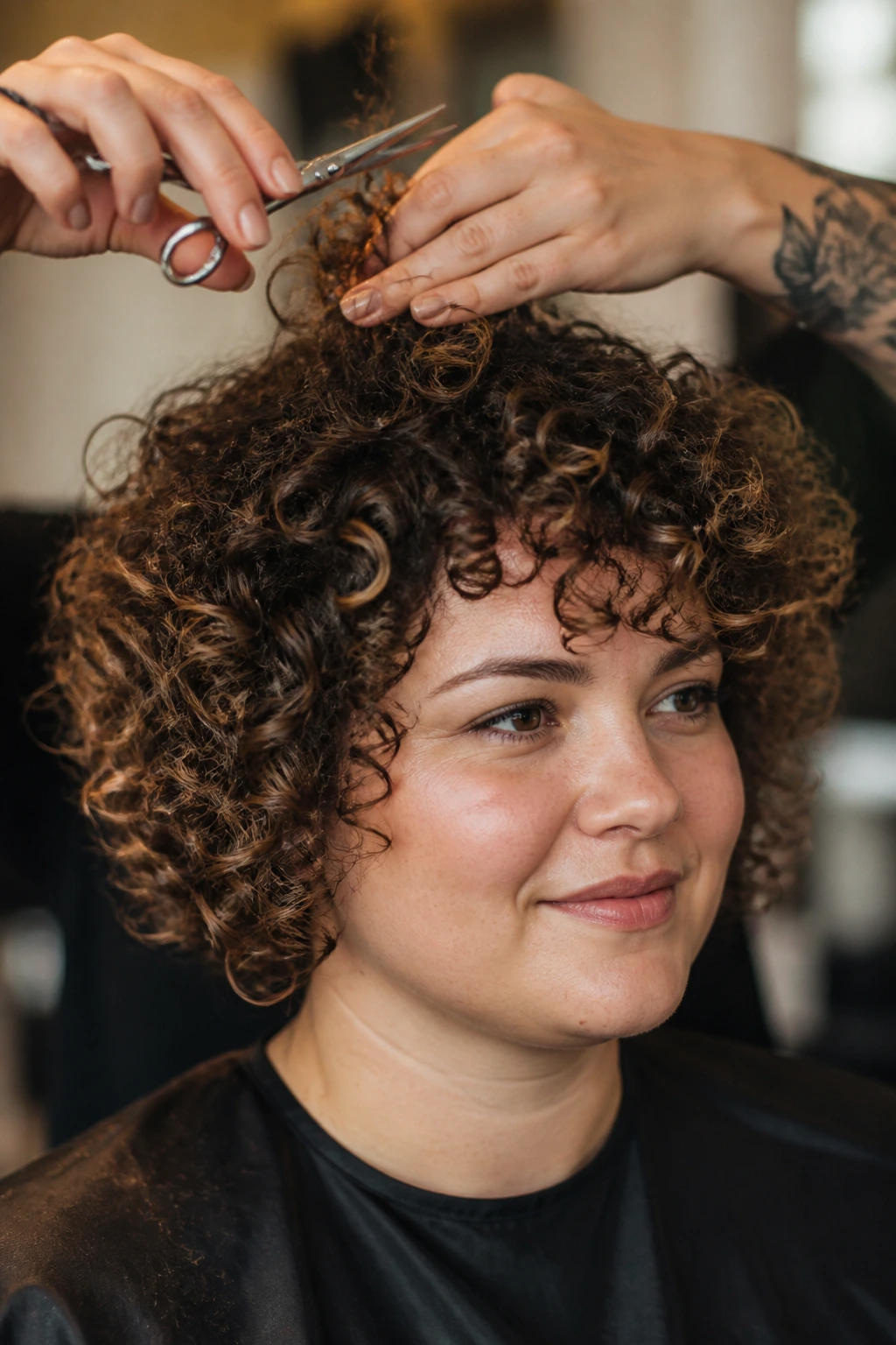 Close-up of real person with curly hair during a cut in a warm salon