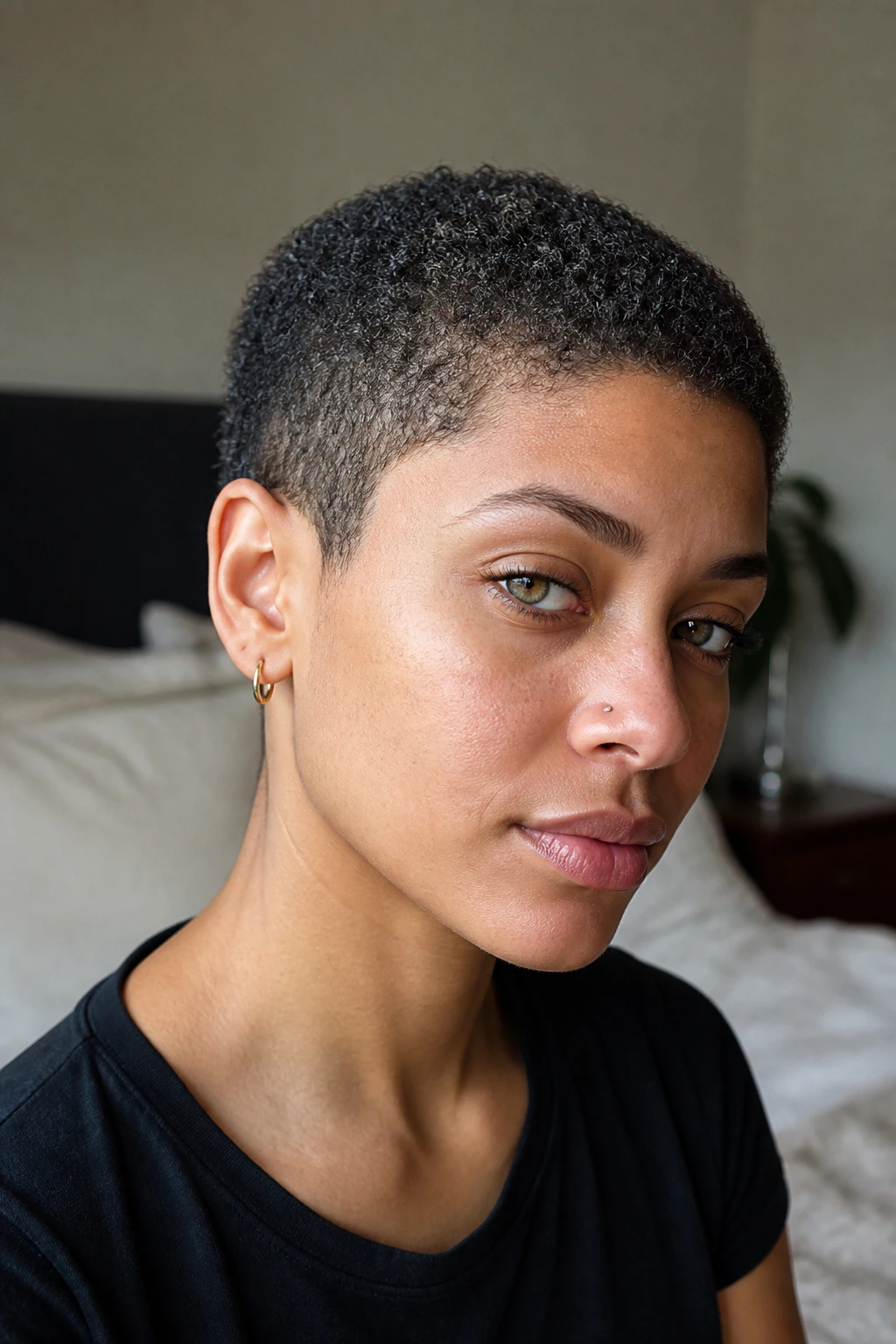 Close-up portrait of a real woman with curly texture buzz cut and crown swirl