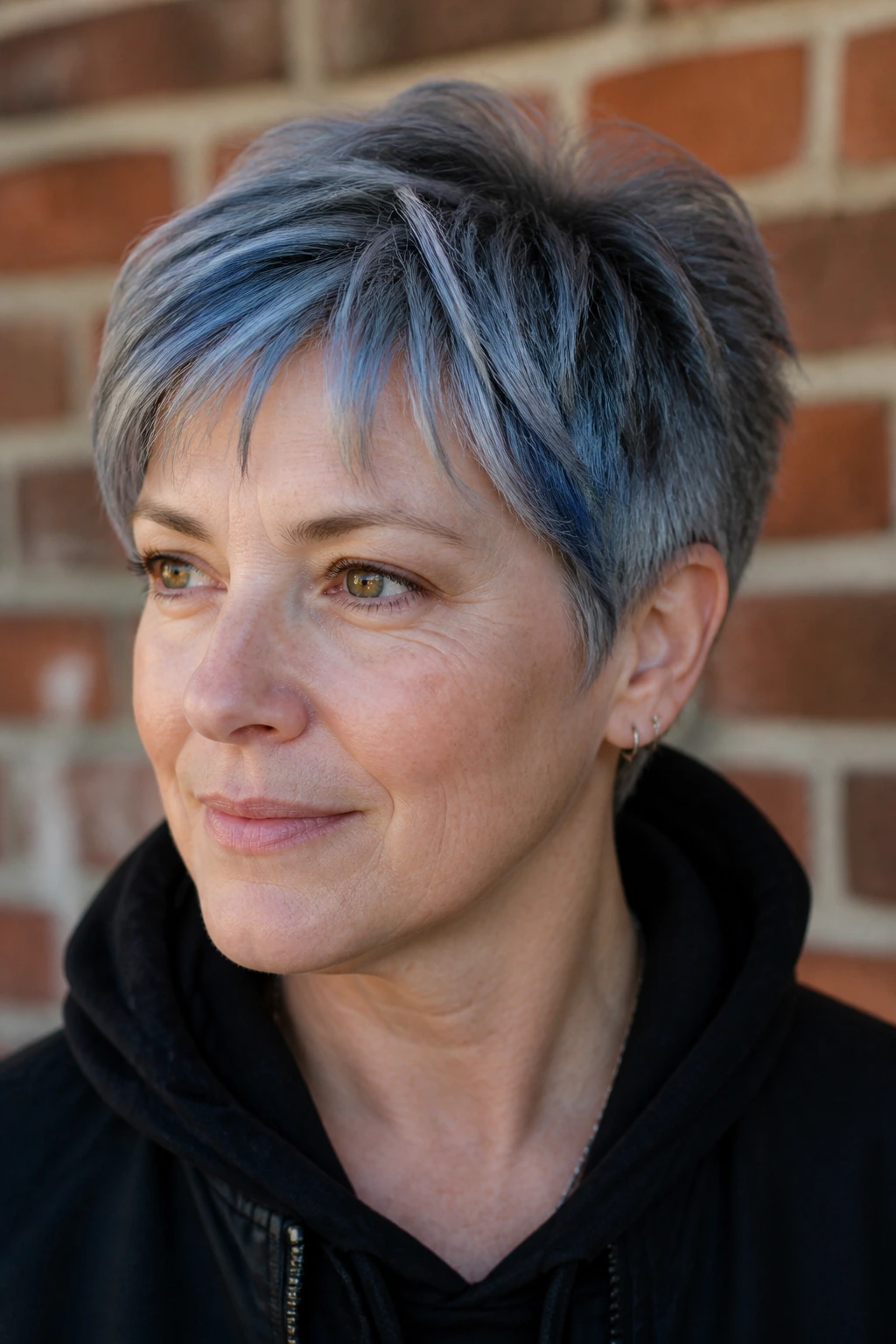 Close-up portrait of short hair with denim gray streaks on a real person, natural daylight.
