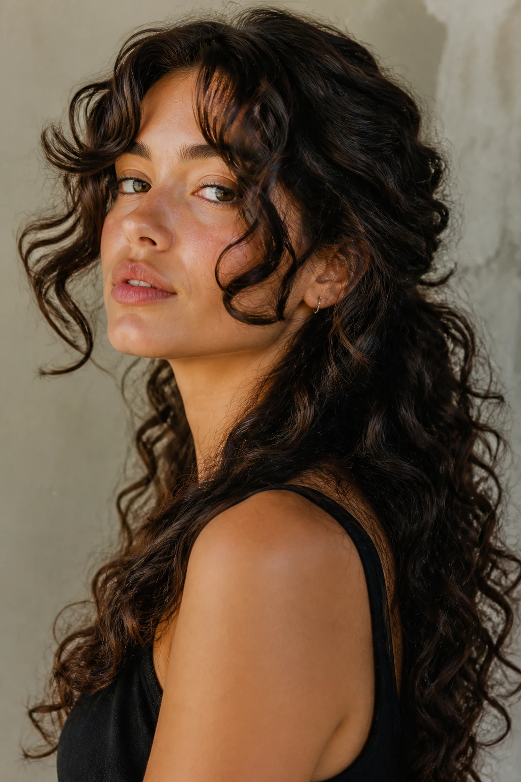 Close-up of a real woman with dramatic face-frame curls.