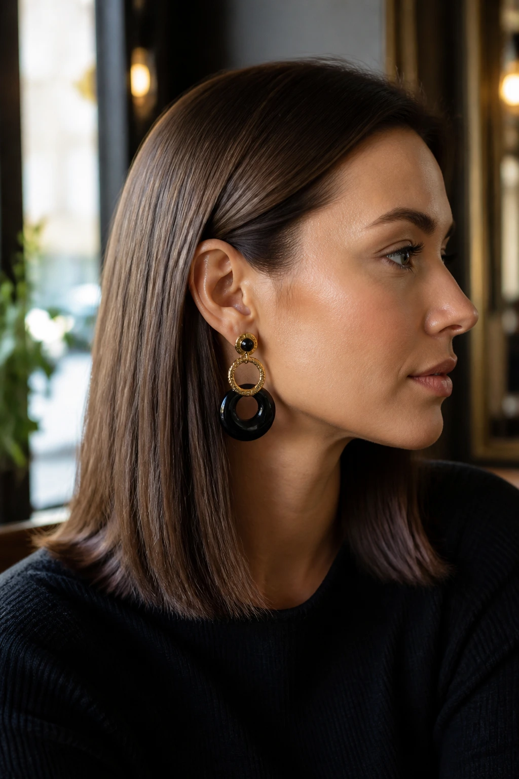Portrait of a real woman with ear-tuck hairstyle showing a statement earring.