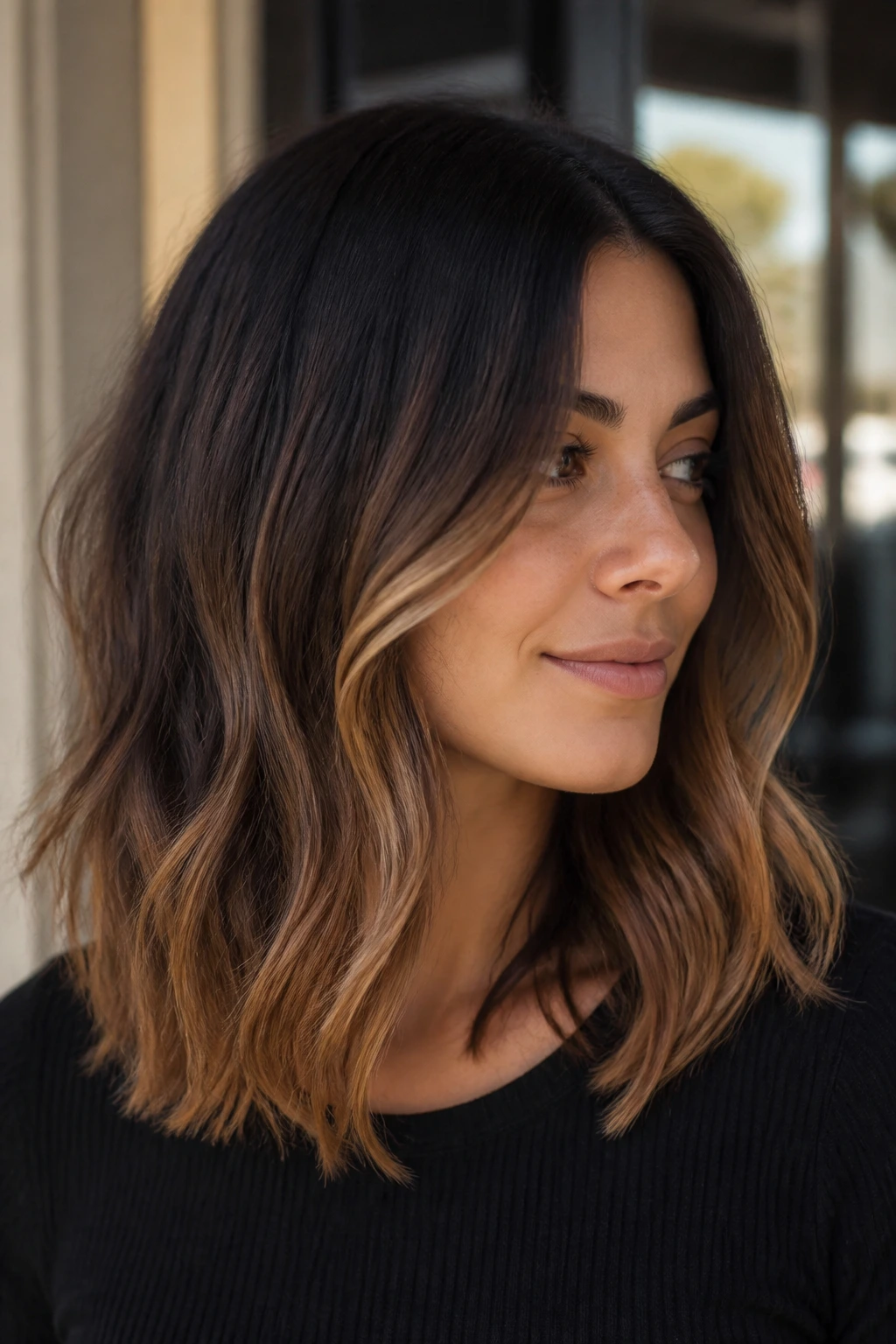 Portrait of a real woman with espresso to caramel ombre in warm salon lighting
