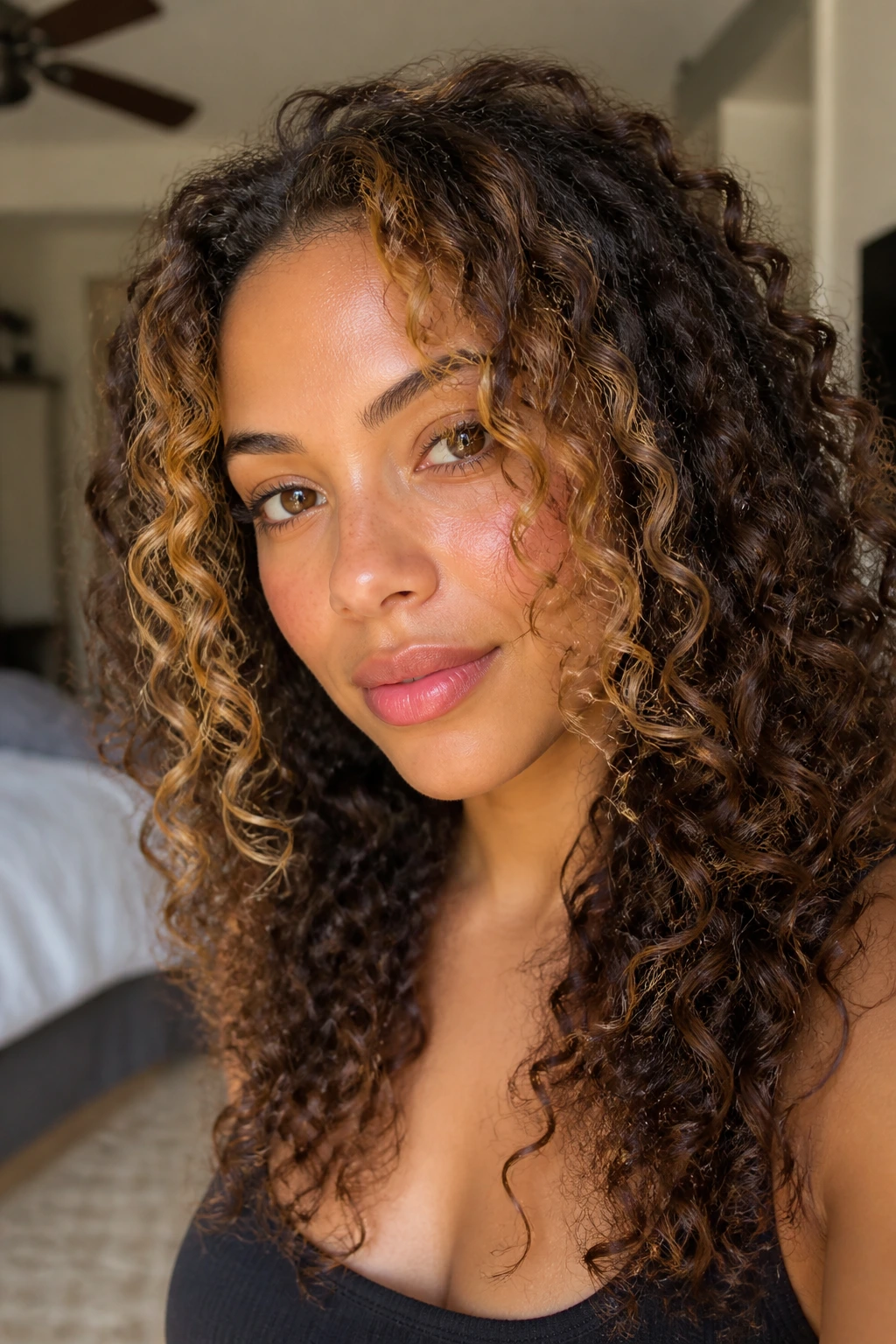 Close-up of honey-toned face-framing highlight on curls around the face