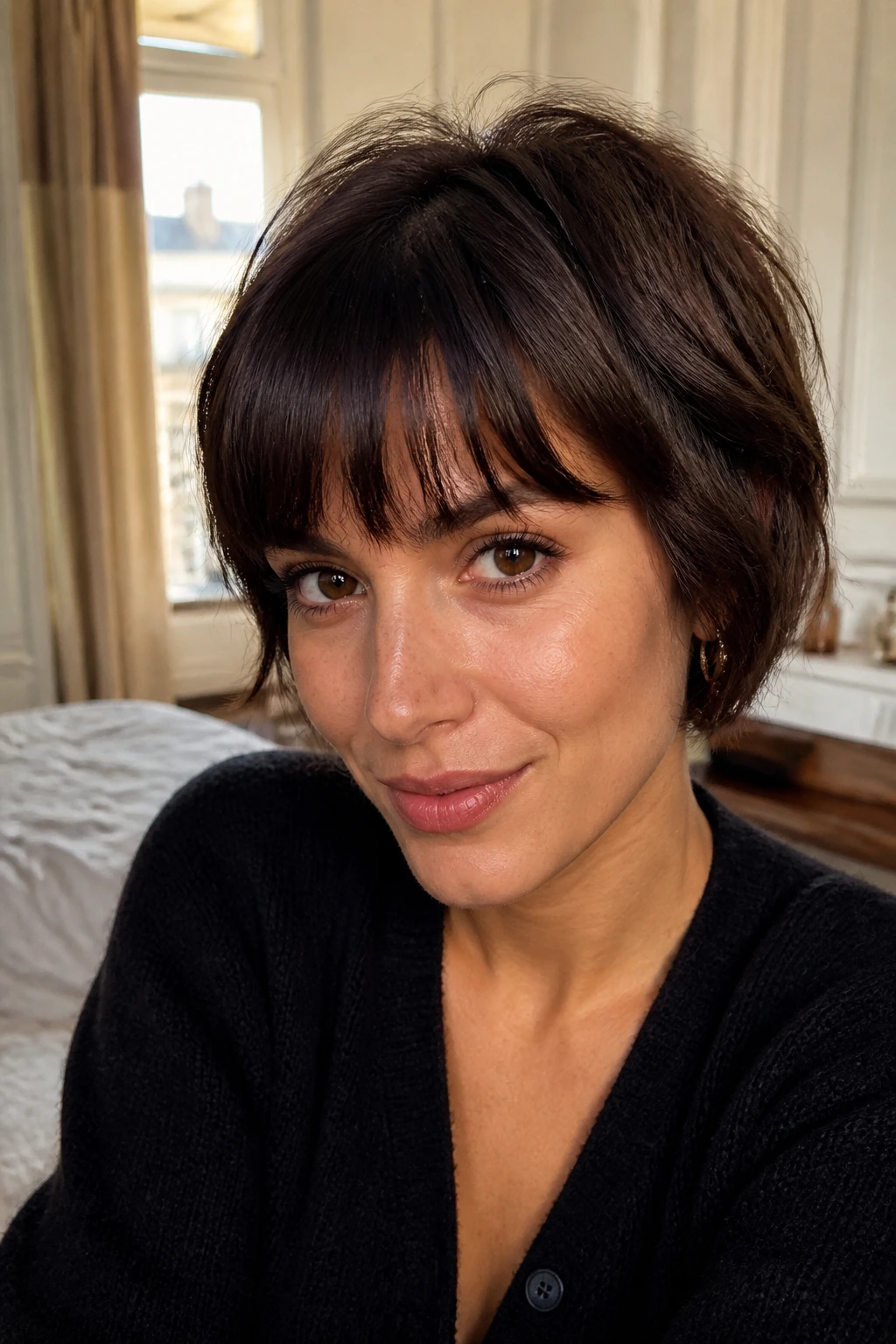 Close-up of a real woman wearing soft, imperfect French-Girl crop bangs with a casual crop