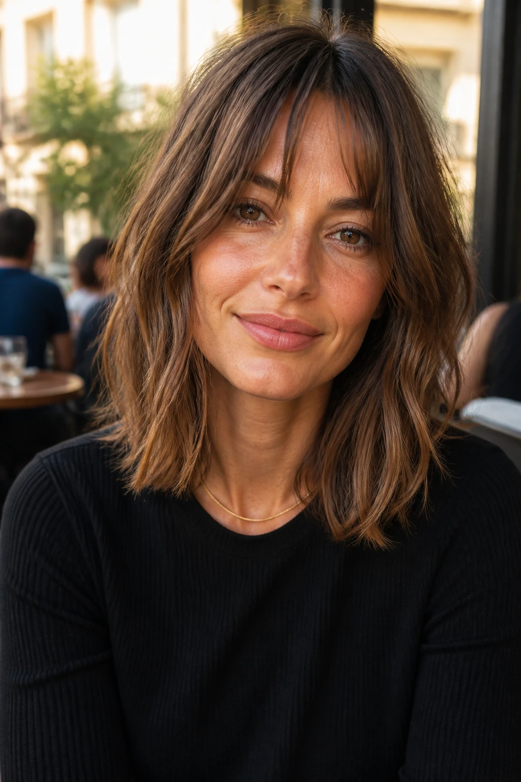 Close-up of real woman with French-girl lob in natural cafe light