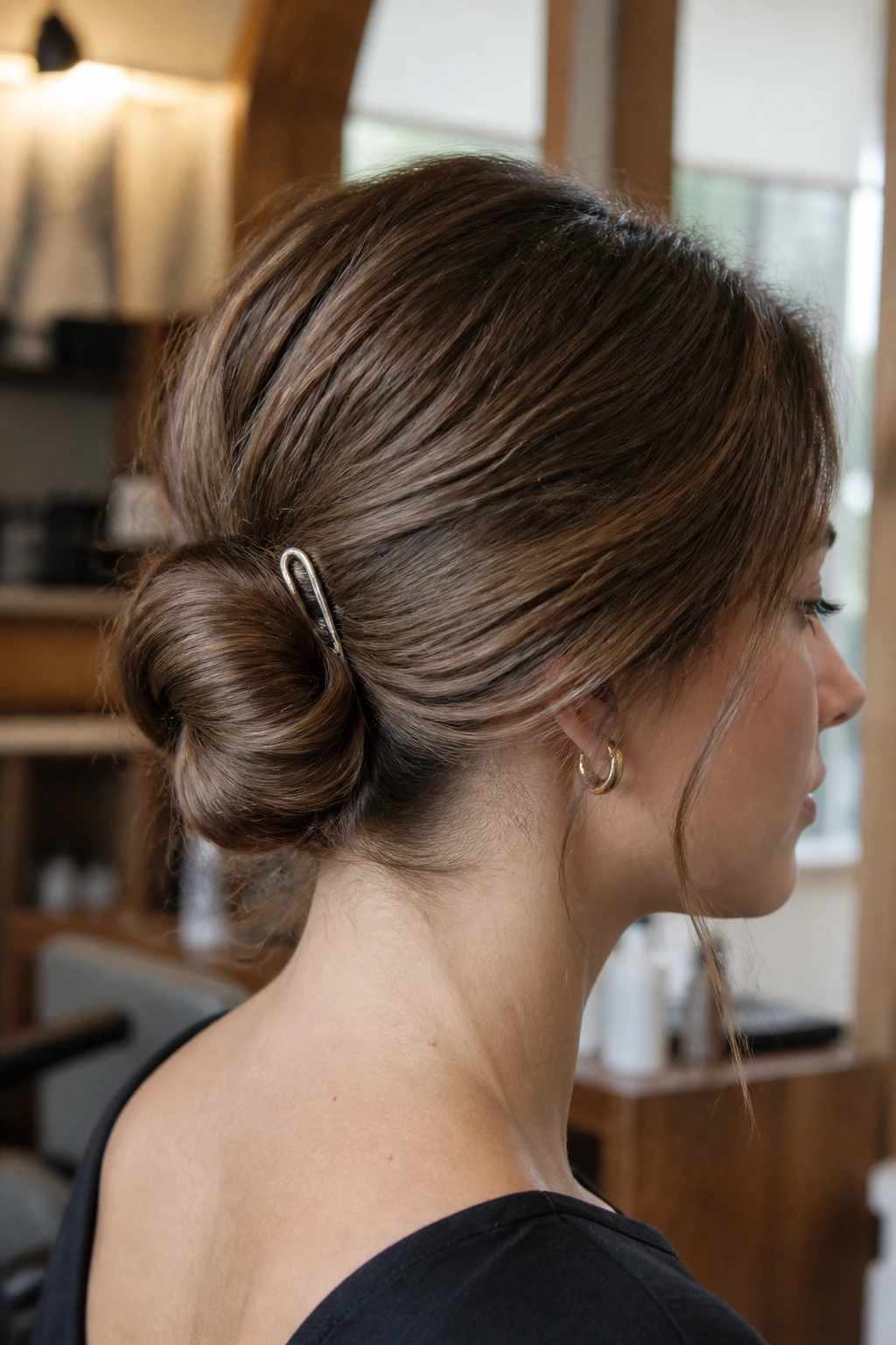 Close-up profile of a woman with a low French-pin coil at the nape
