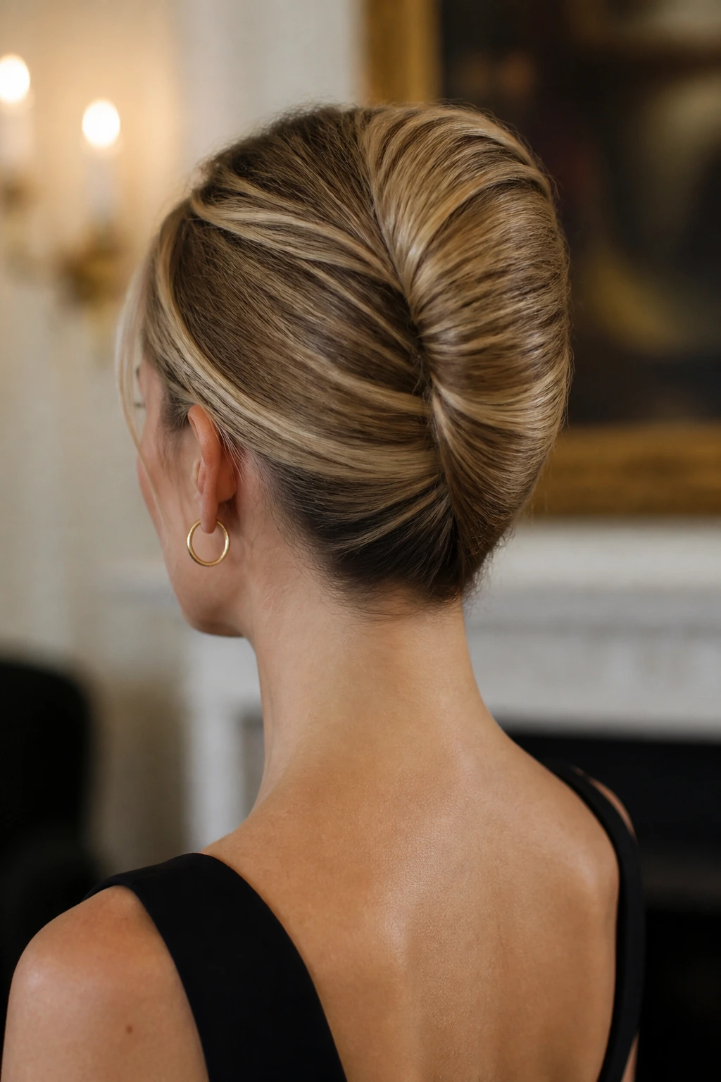 Close-up rear-view of a real woman with a slim French twist at the back of the head.
