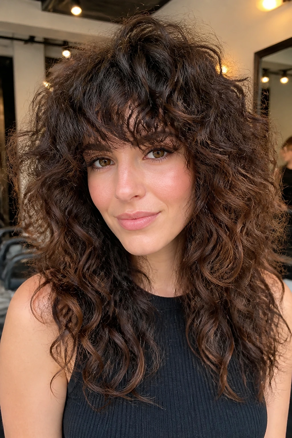 Portrait of a real woman with full fringe shag and curly hair in a bright salon.