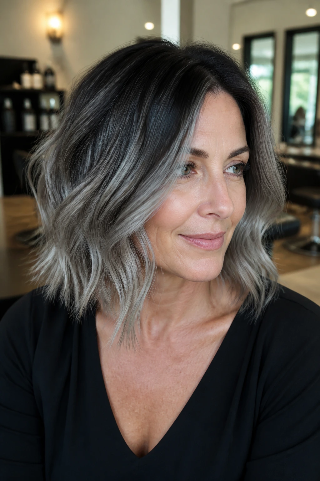 Portrait of a woman with smoky gray balayage and dark roots, color transition highlighted
