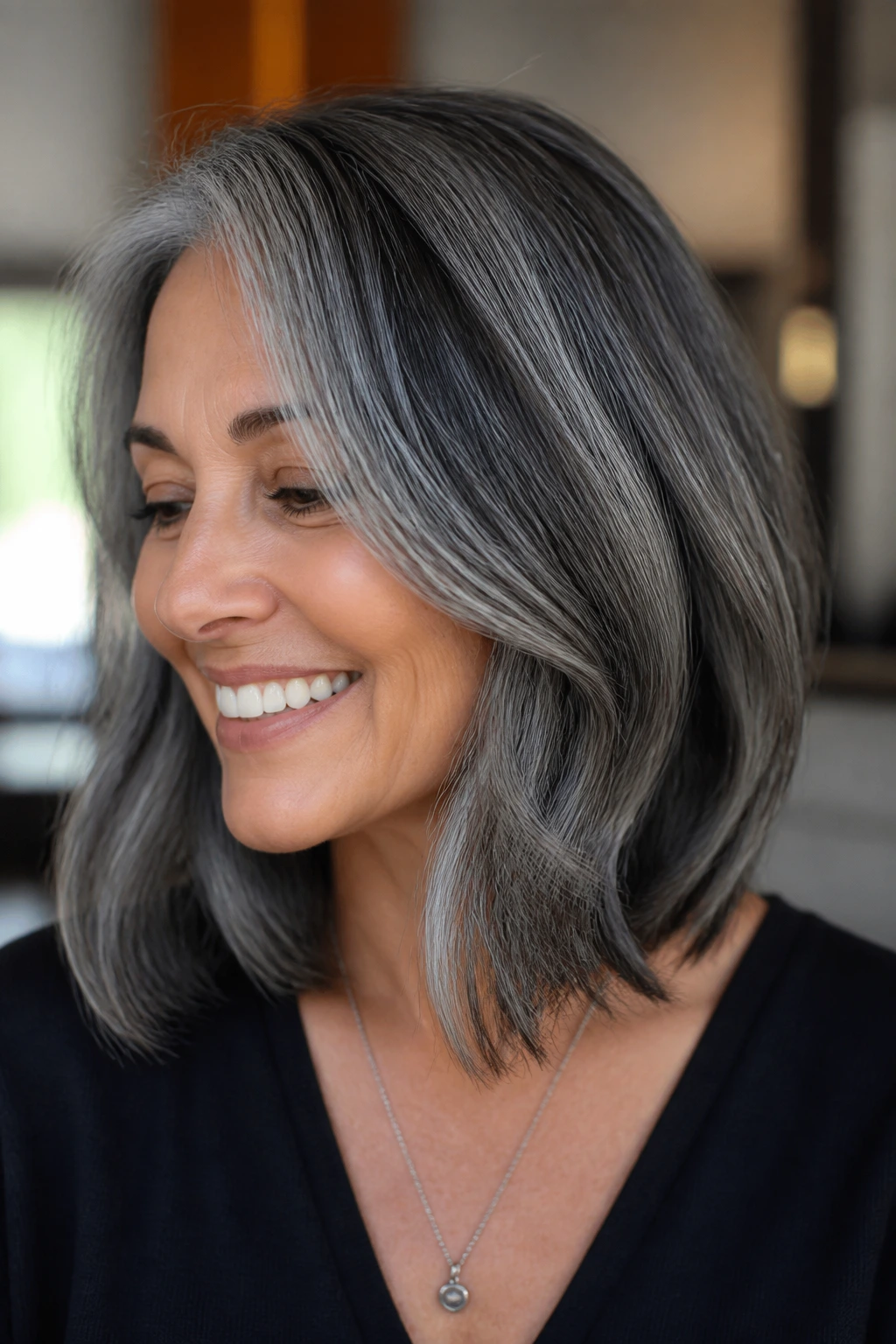 Close-up of a real person with charcoal lowlights on gray hair.