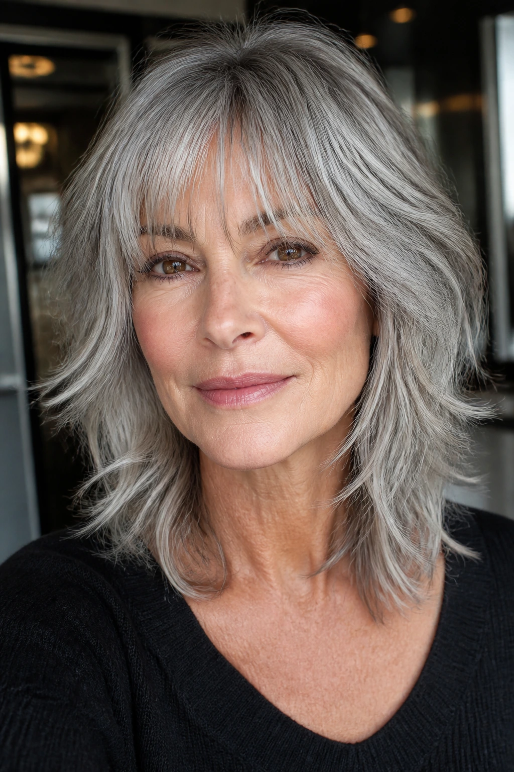 Portrait of a woman with a silver shag and airy bangs in gray hair