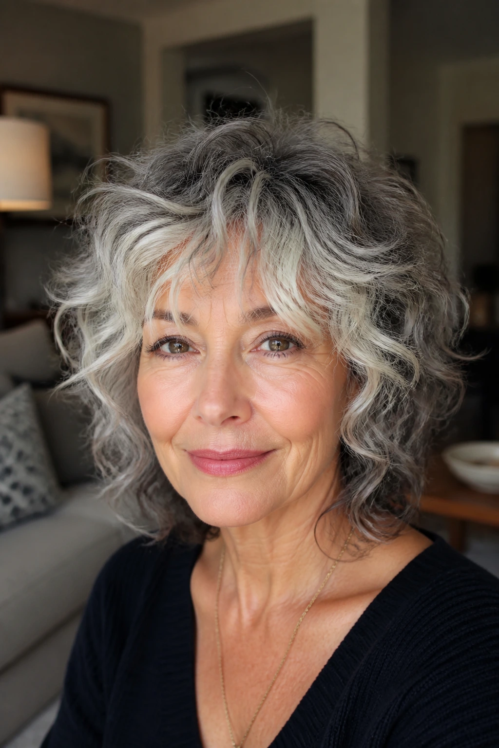 Older woman with salt-and-pepper curly shag and lighter face-framing fringe