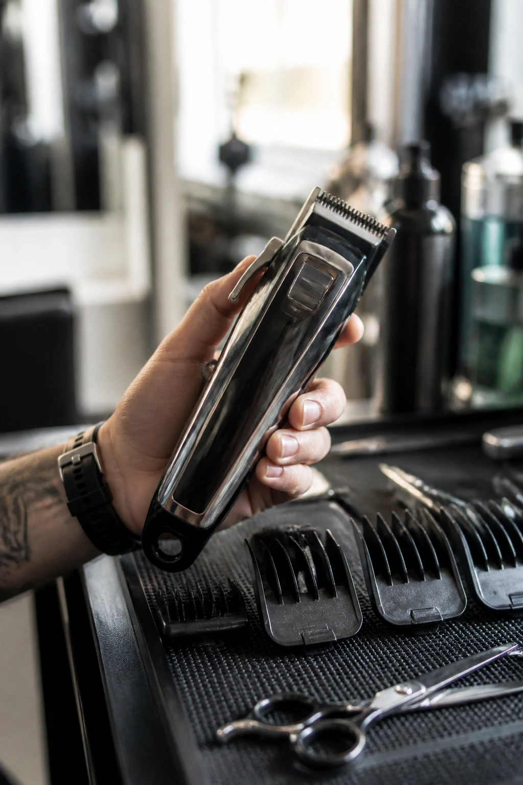 Close-up of professional hair clipper with guards in a salon setting.