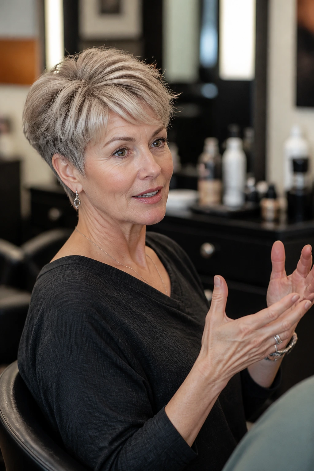 Real woman in a salon chair explaining haircut preferences for a pixie cut.