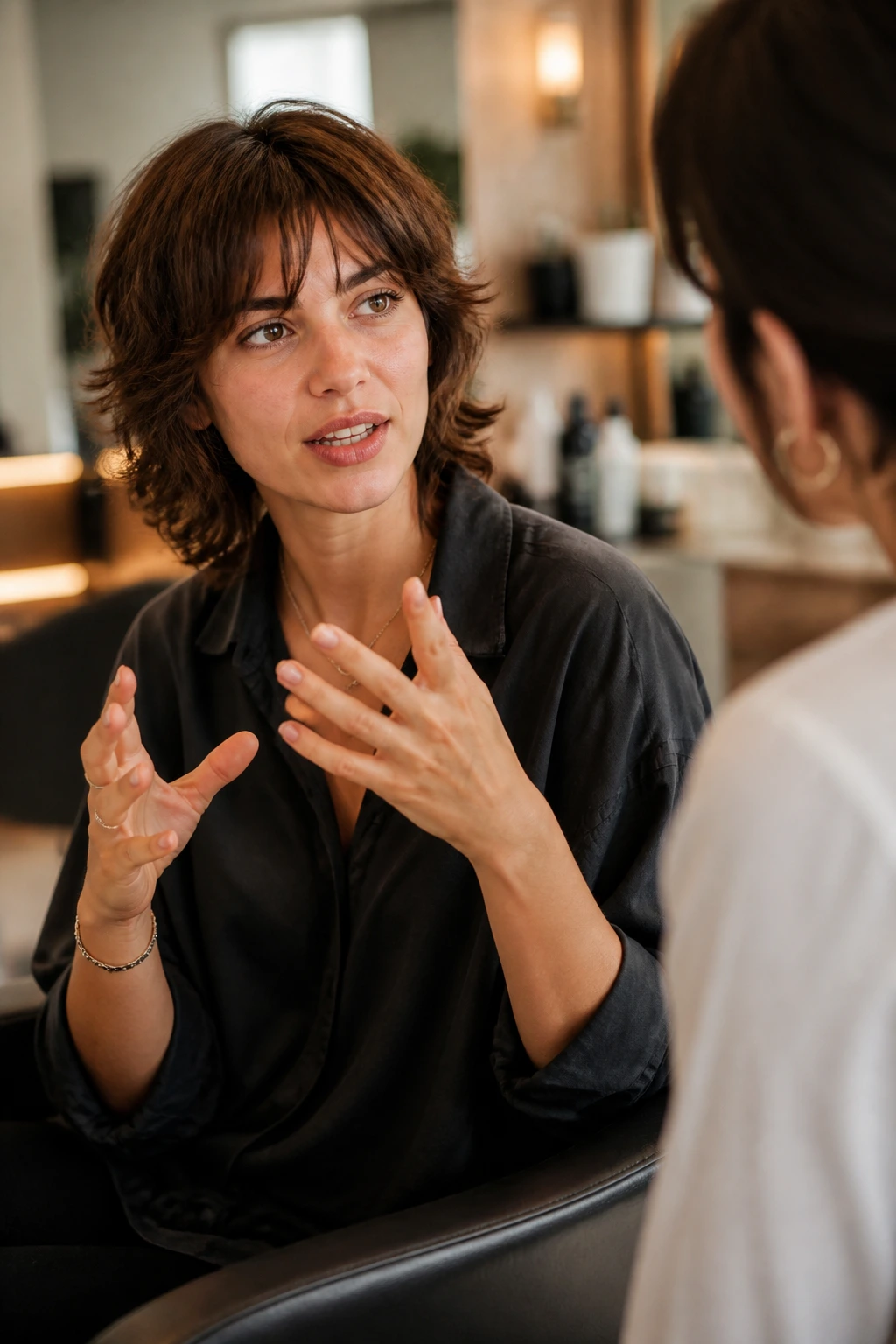 Portrait of client and stylist in a salon discussing shag haircut preferences.